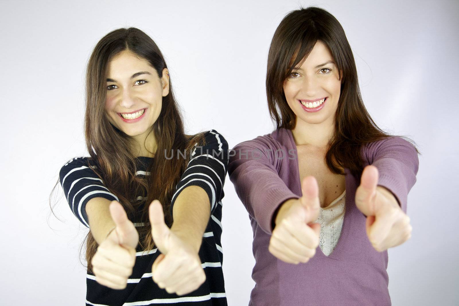Two girls very happy with thumbs up smiling