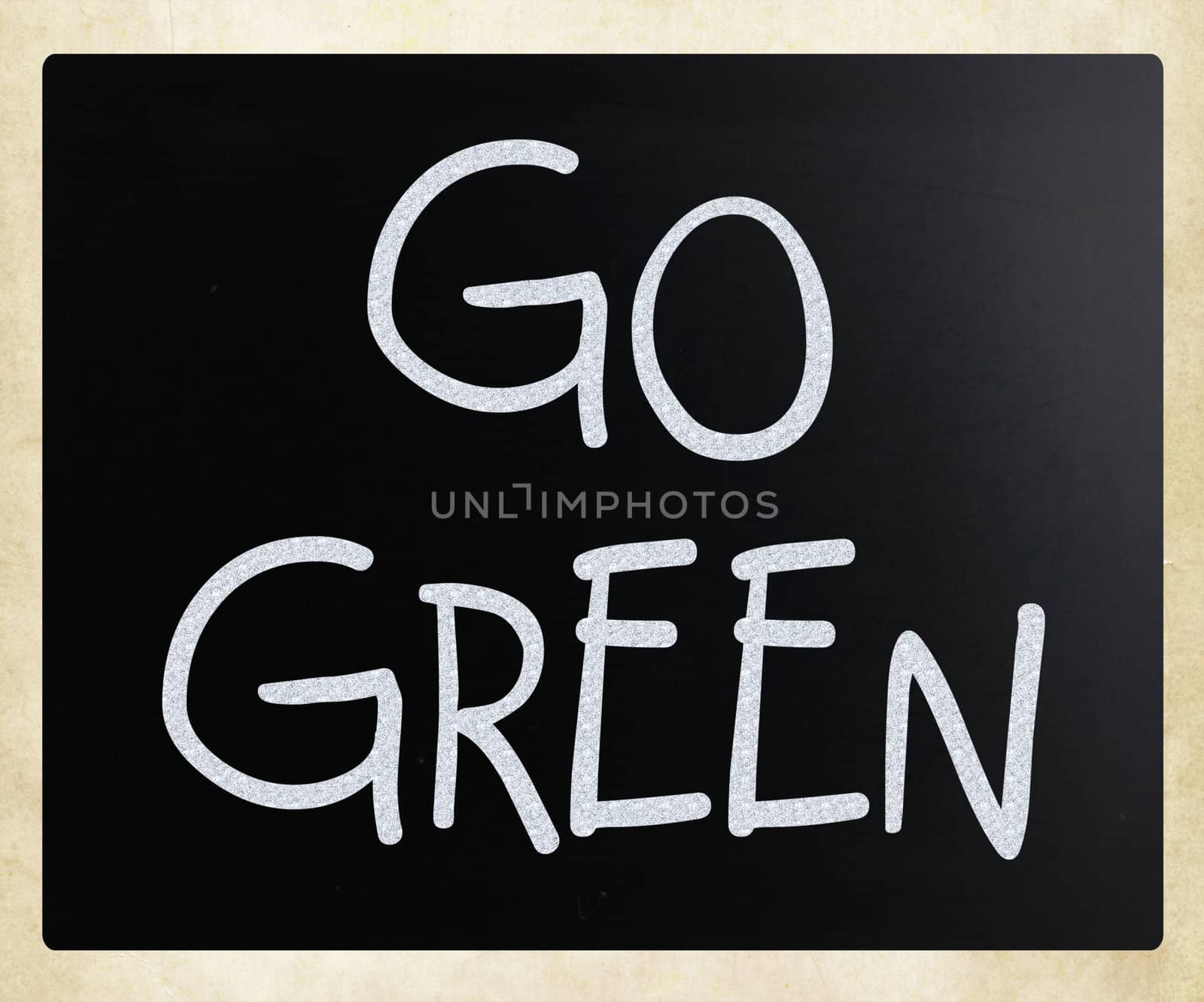 "Go green" handwritten with white chalk on a blackboard by nenov