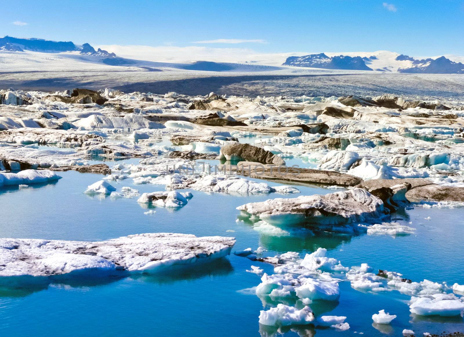 Small iceberg melting in iceland Sea with arctic mountains in background