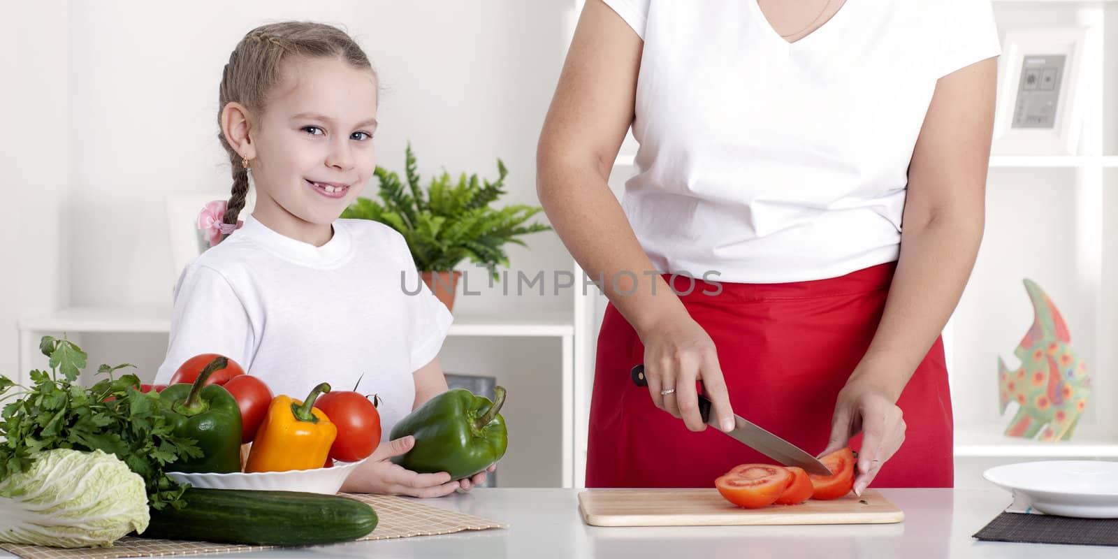 Mother and daughter cooking vegetable salad together