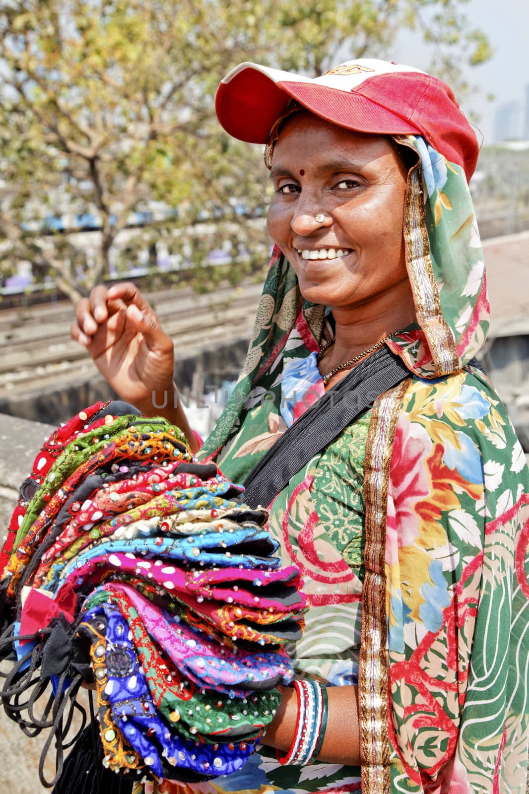 Mumbai tourist spot, Dhobhi Ghat, portrait of colorful smiling purse street vendor with baseball hat