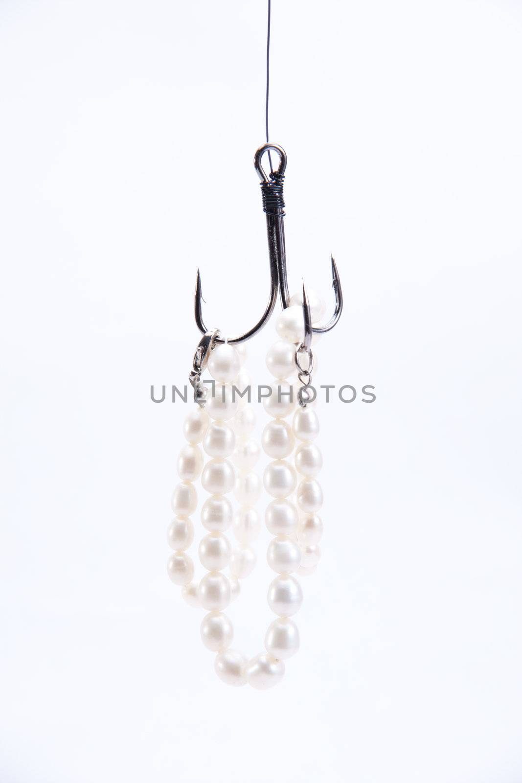 jewelry made of pearls hanging on fishing hook. not isolated