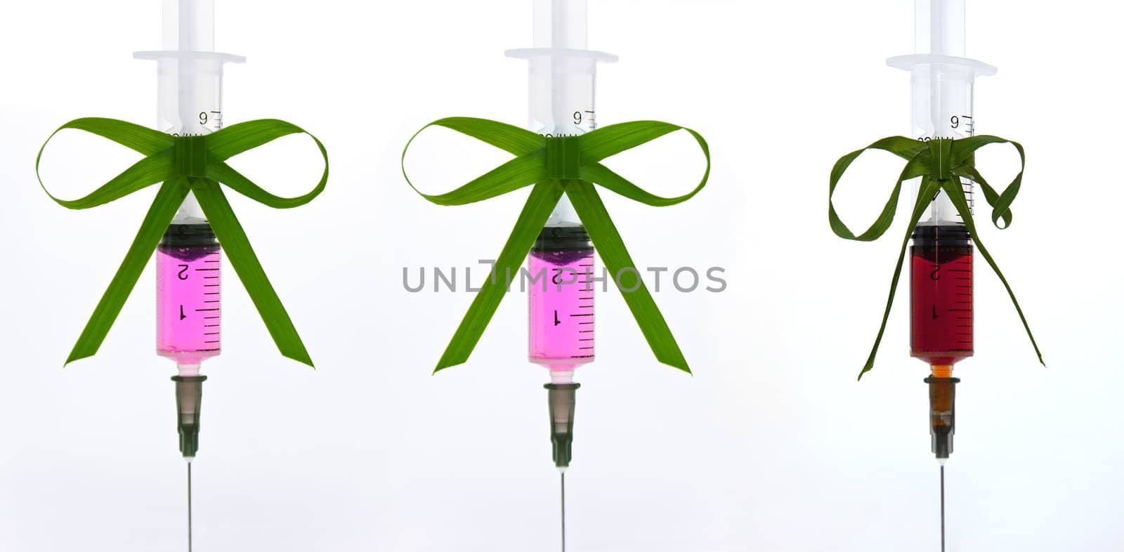 syringe with a pink liquid with a ribbon of grass with a vignette