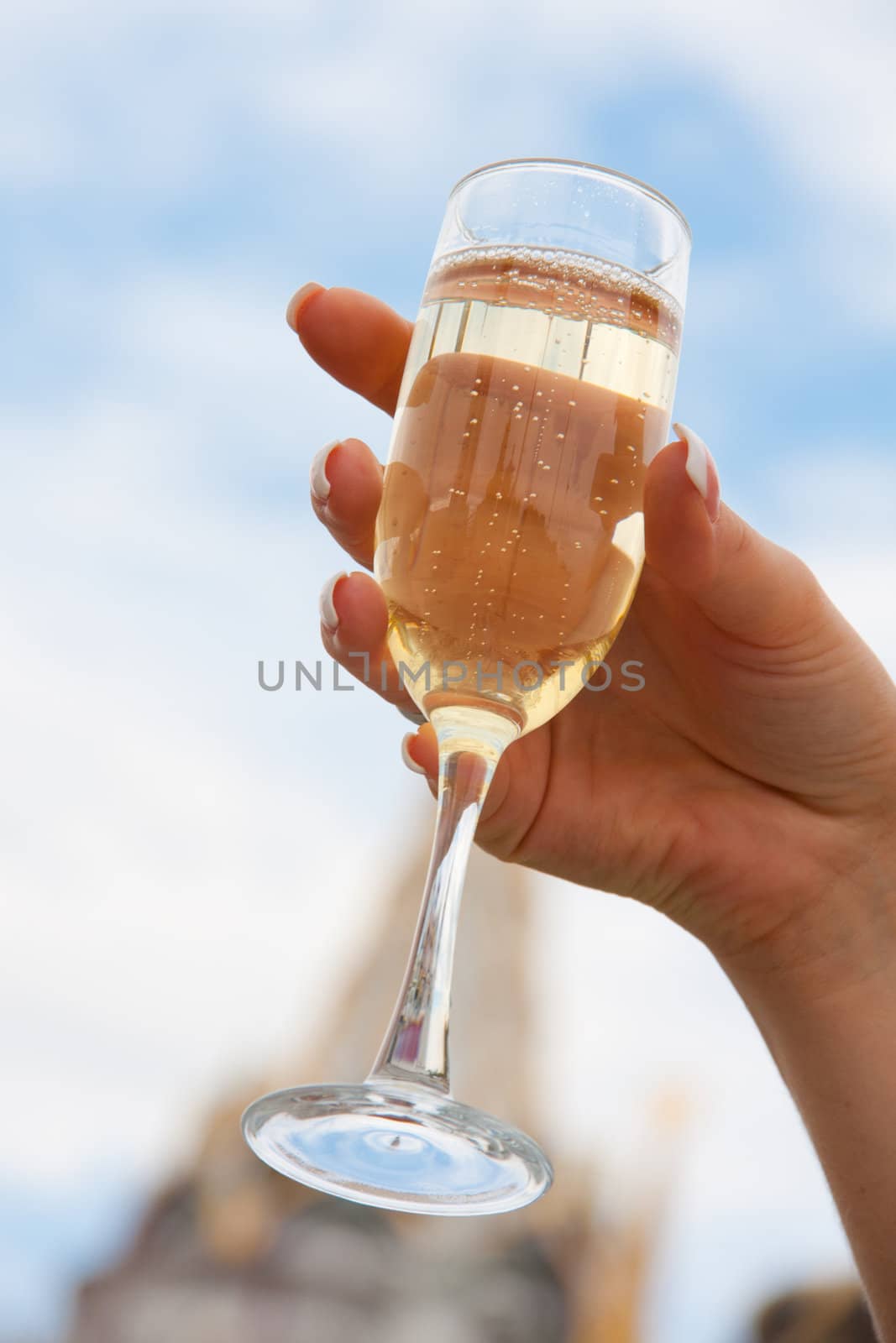 Bride holding a glass of golden champagne in hand