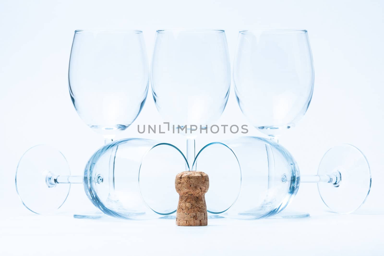 glass wine stand symmetrically with cork of bottle on white