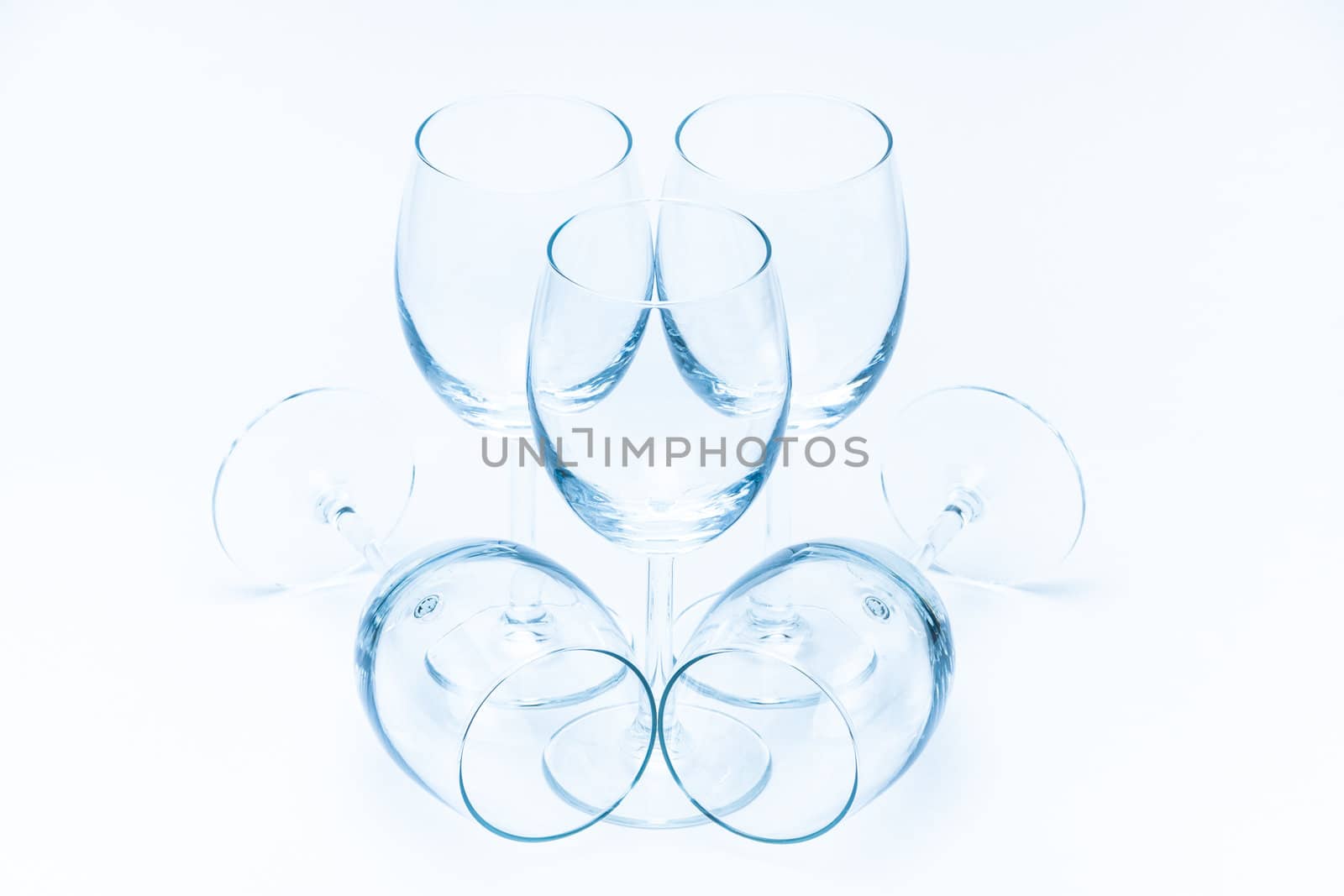 Empty wine glasses stand symmetrically on a white background