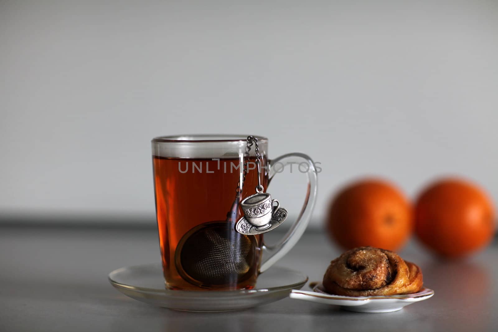 cup of strong black tea biscuit and two orange