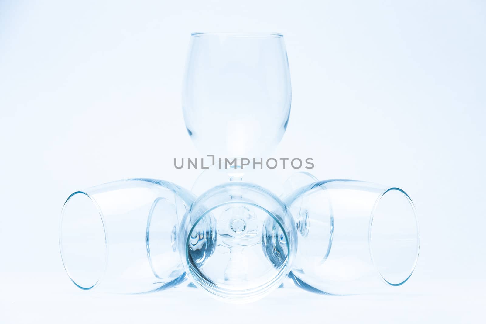 Wine glasses stand and lie symmetrically on white by vitmihailov