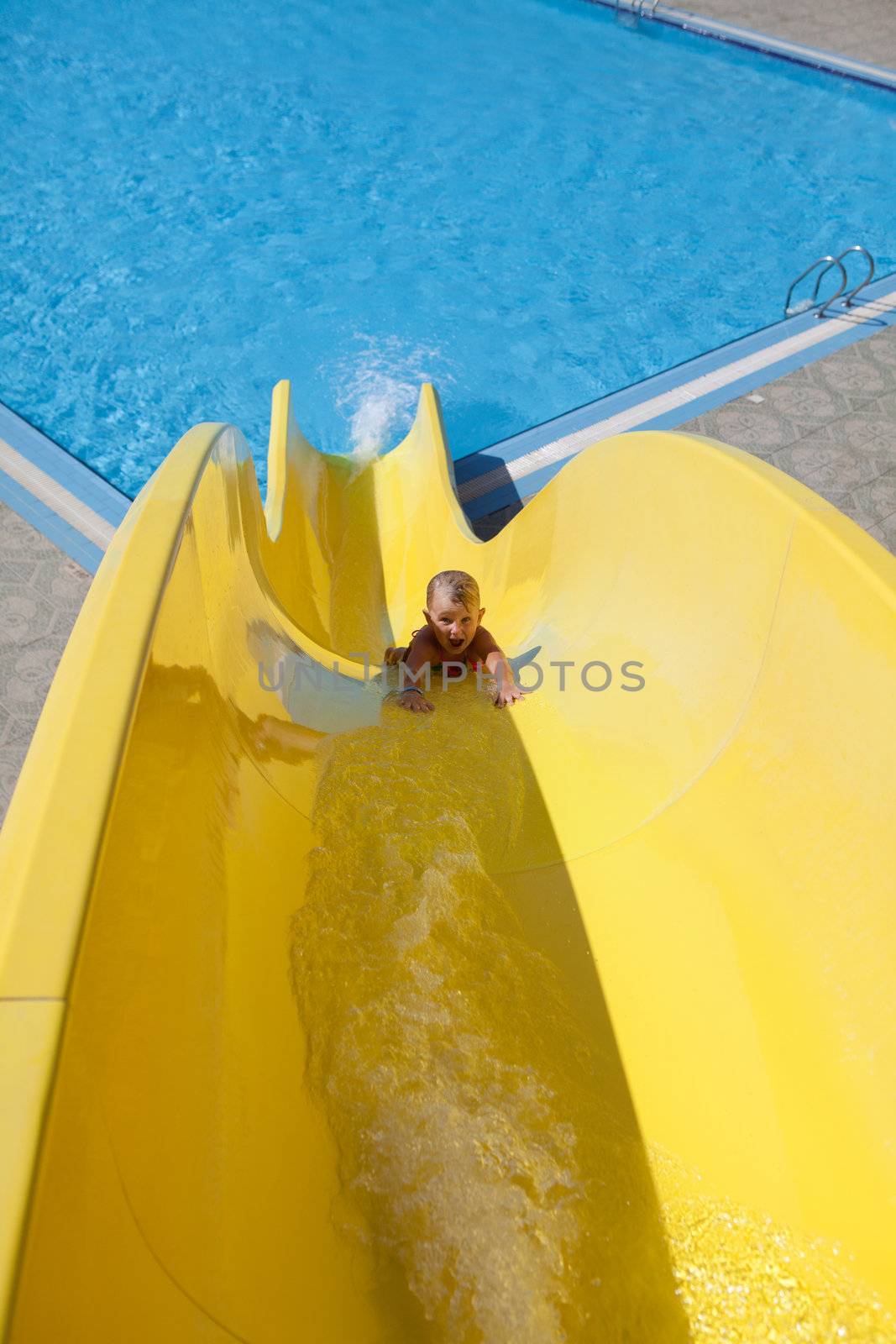 pretty little girl goes down on slide