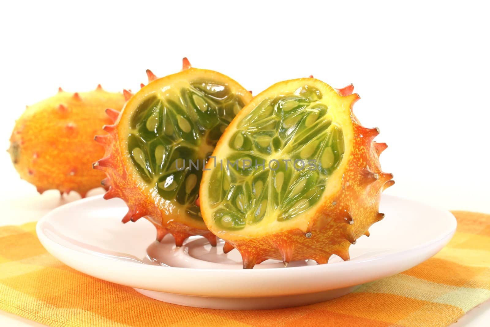 fresh sliced orange Kiwano on a white plate