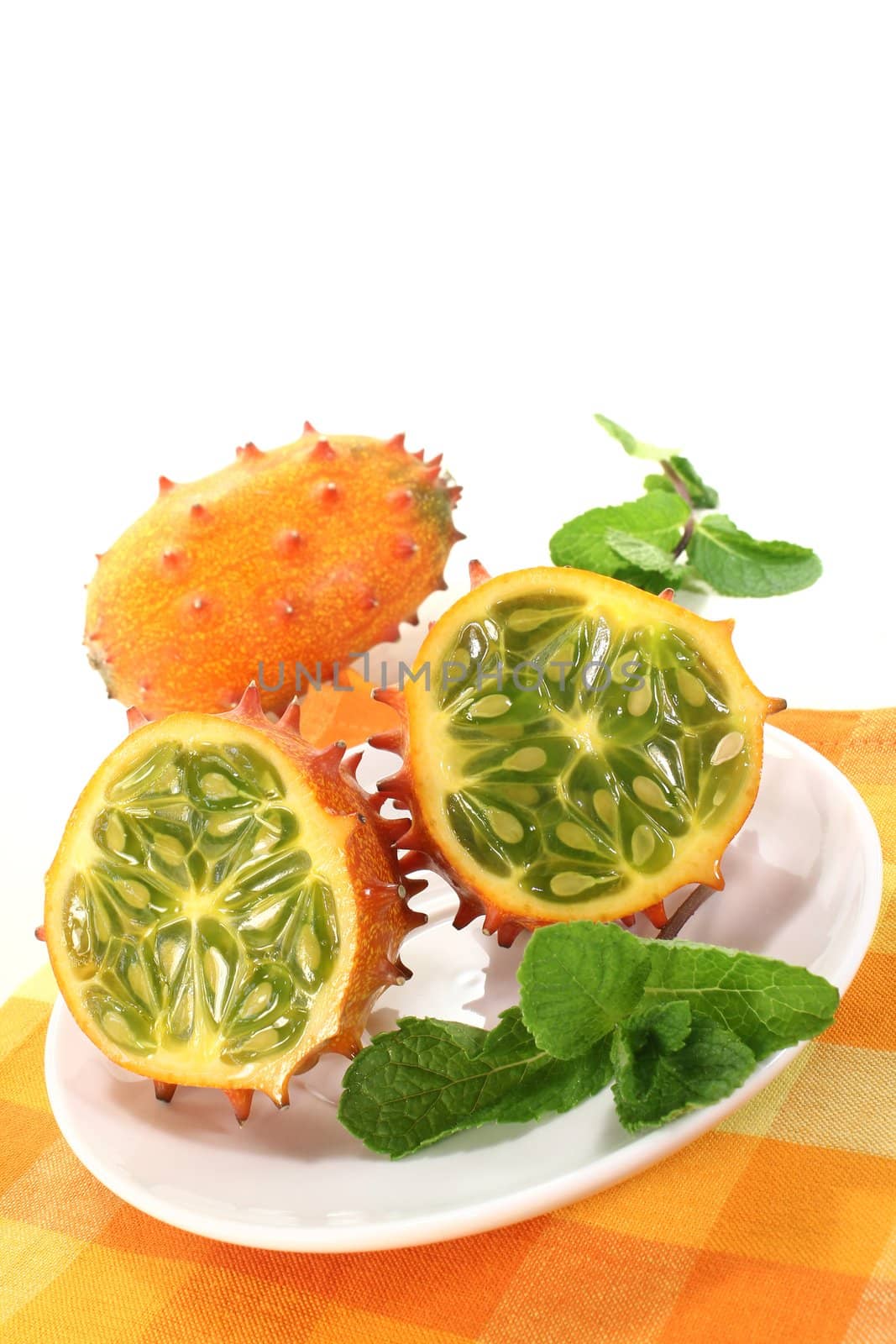 fresh sliced orange Kiwano on a light background