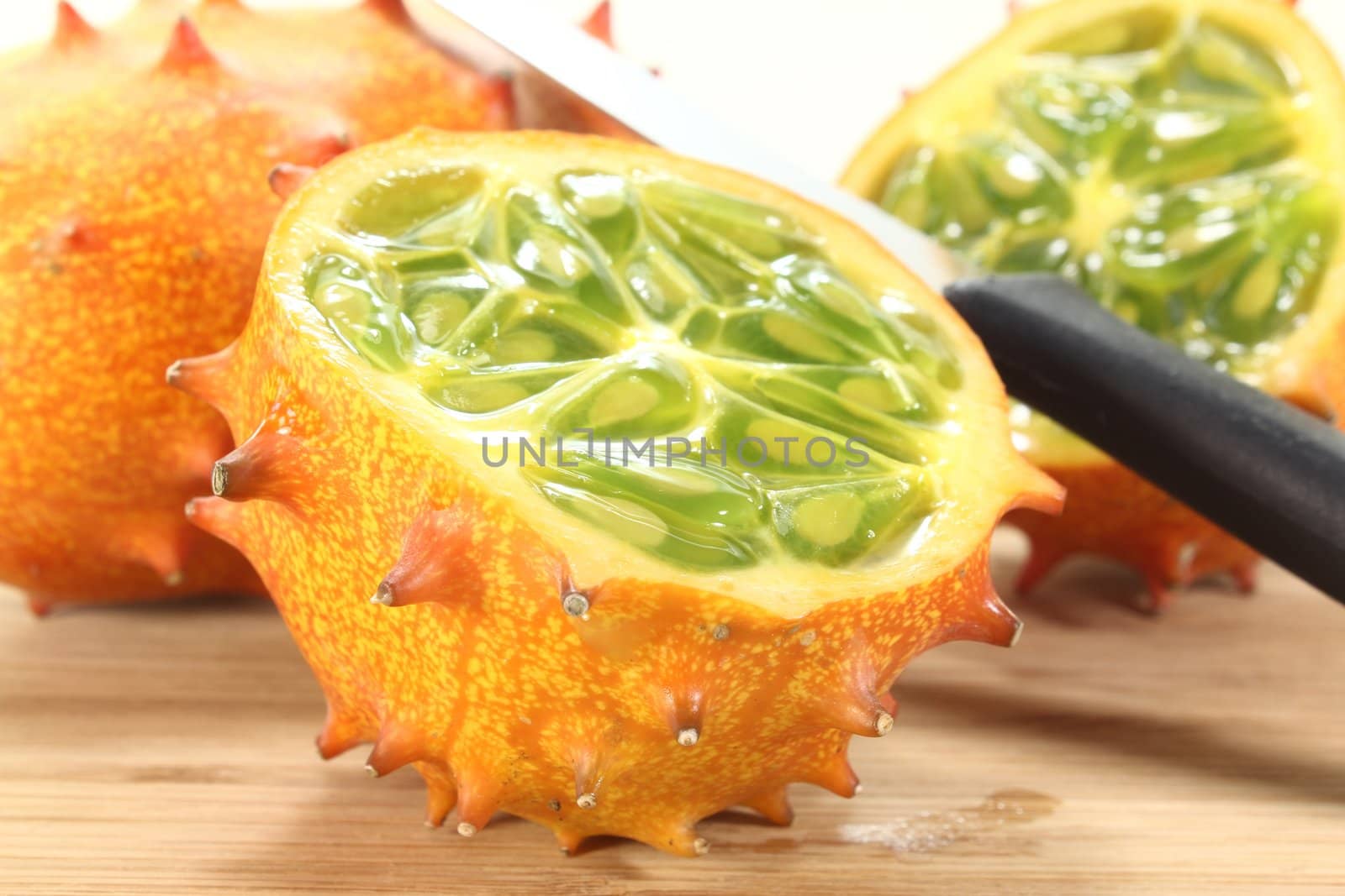 fresh sliced orange Kiwano on a wooden board