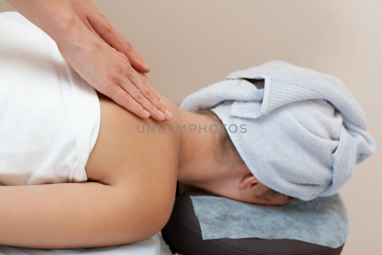 young woman in a spa salon lays on a table and receives a massage