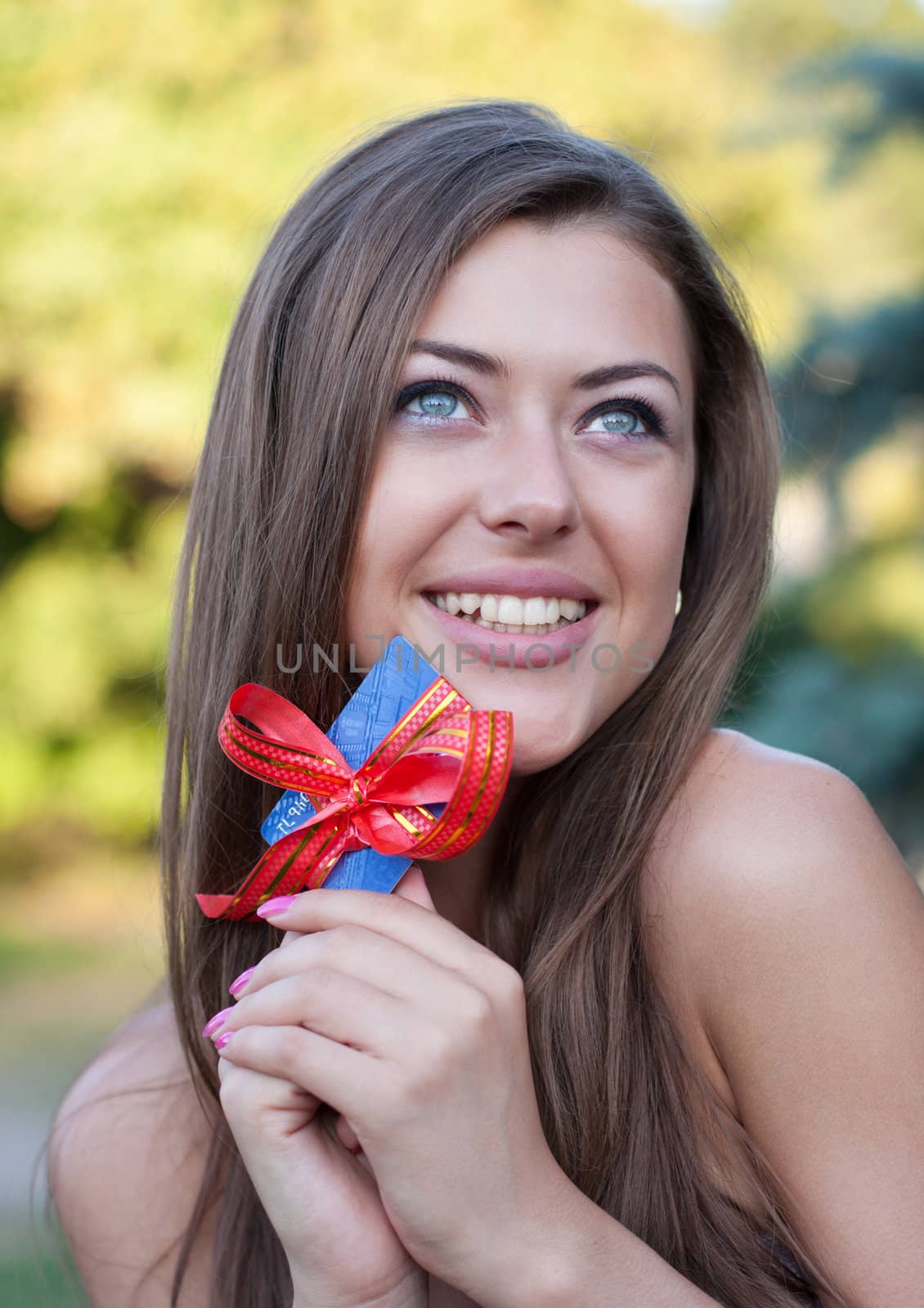 young woman holds in hands a credit card as a gift and smiles. Business style