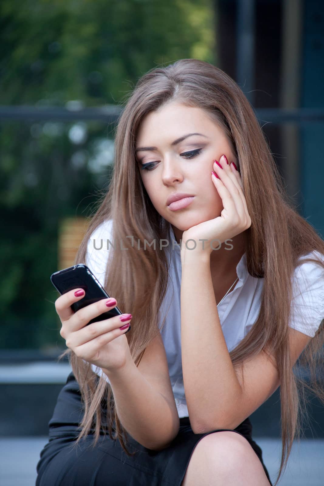 young woman looks in phone having seen something by vitmihailov
