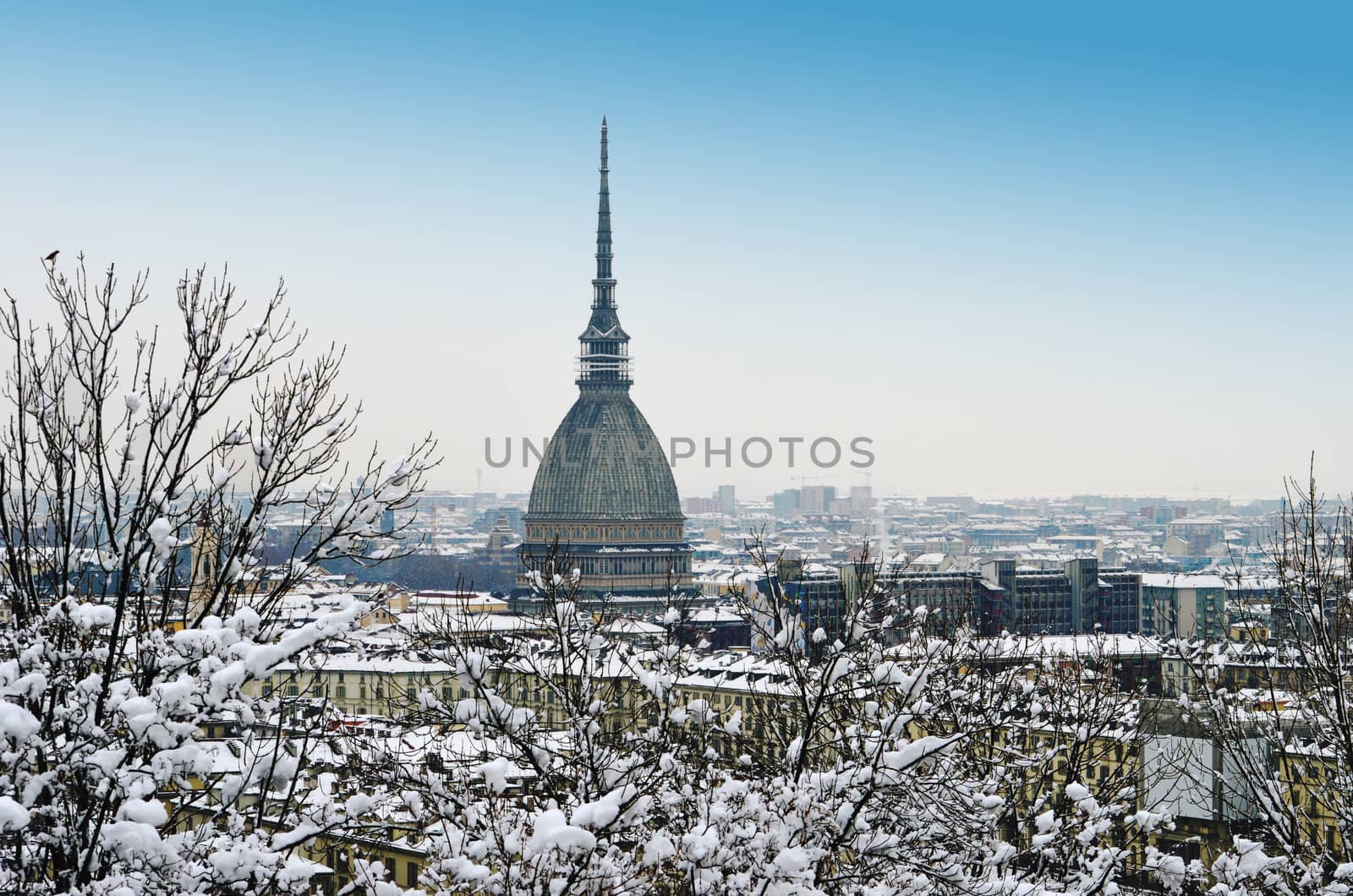 Turin, Italy, in winter. Snow covered roofs and Mole Antonelliana