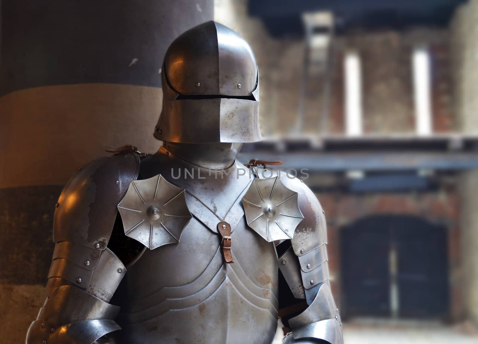 Man in a medieval armor with castle walls in background