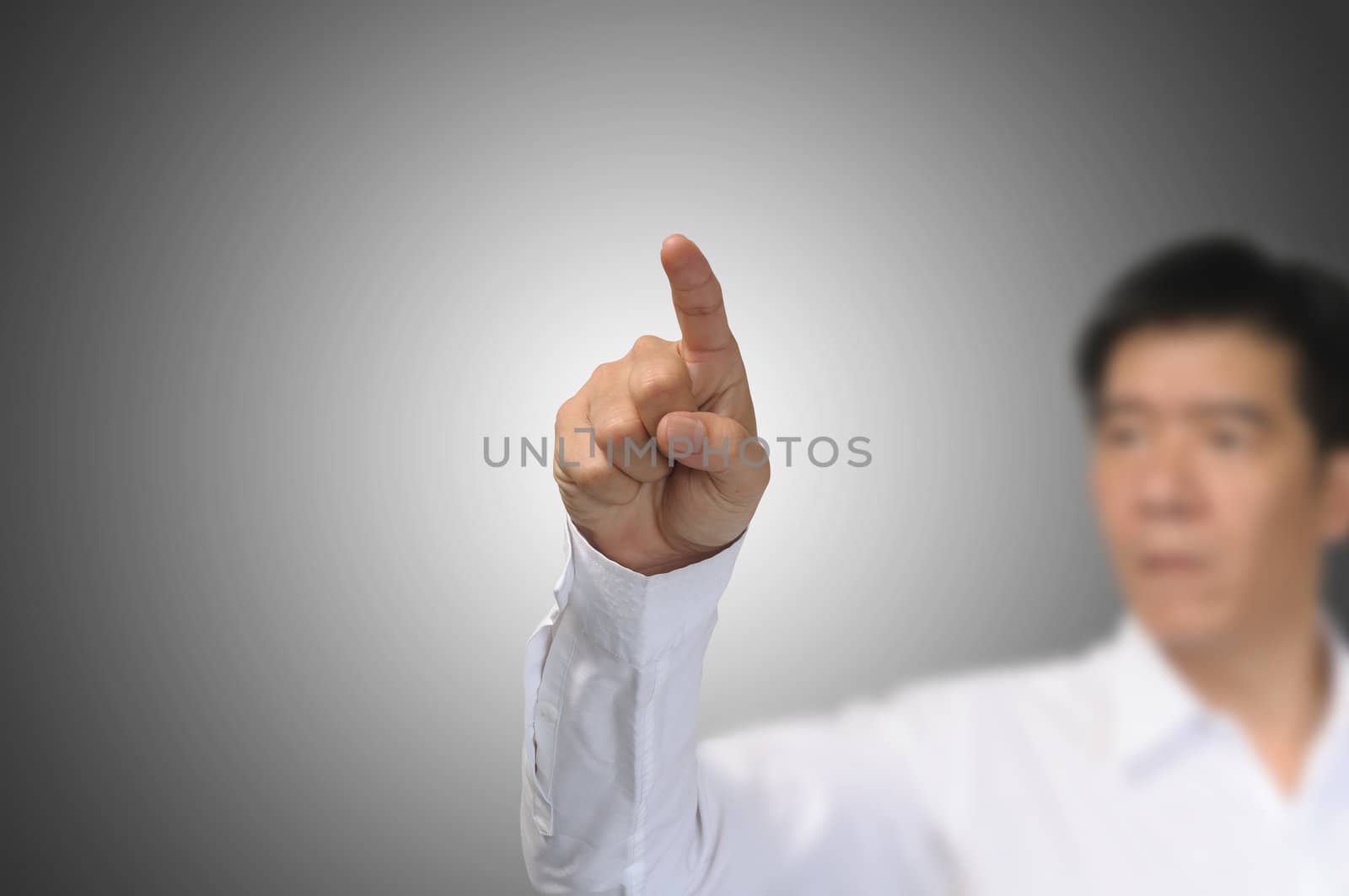 Business Man Pointing on gradient grey background  by thampapon