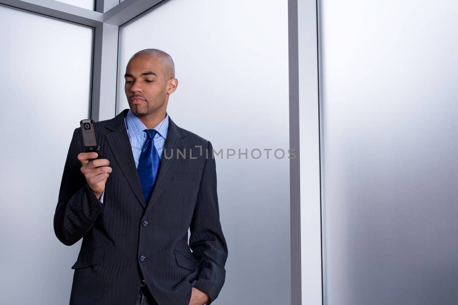 Businessman dialing a number on his cell phone by anikasalsera