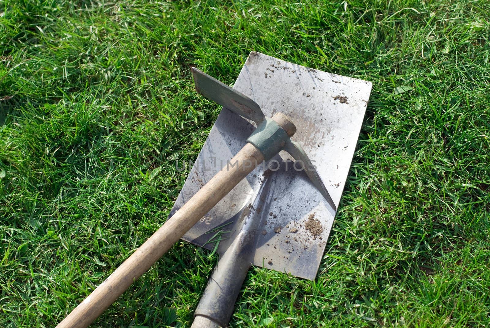a shovel and a pick on the grass