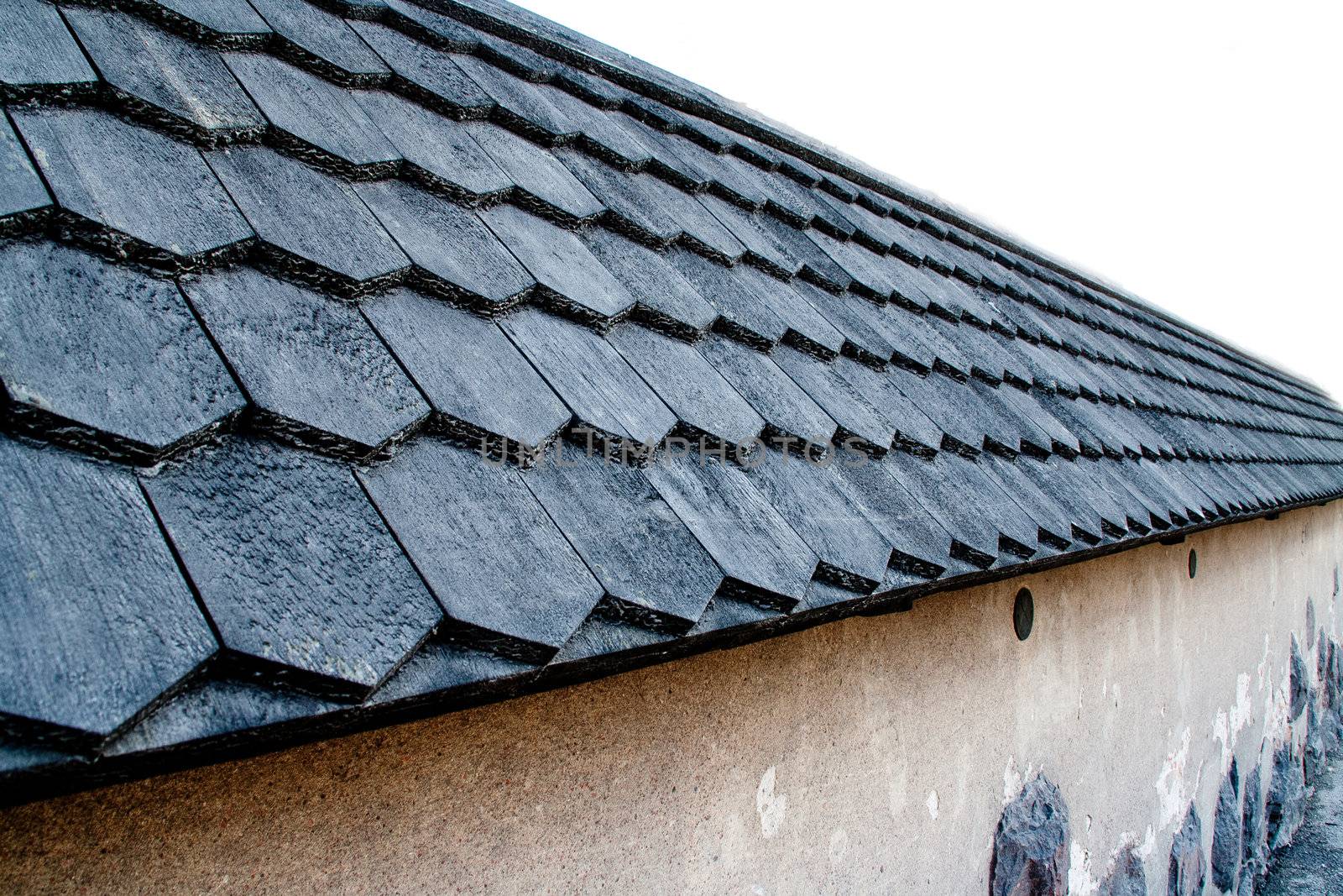 Black roof with a concrete wall. Sky made pure white.