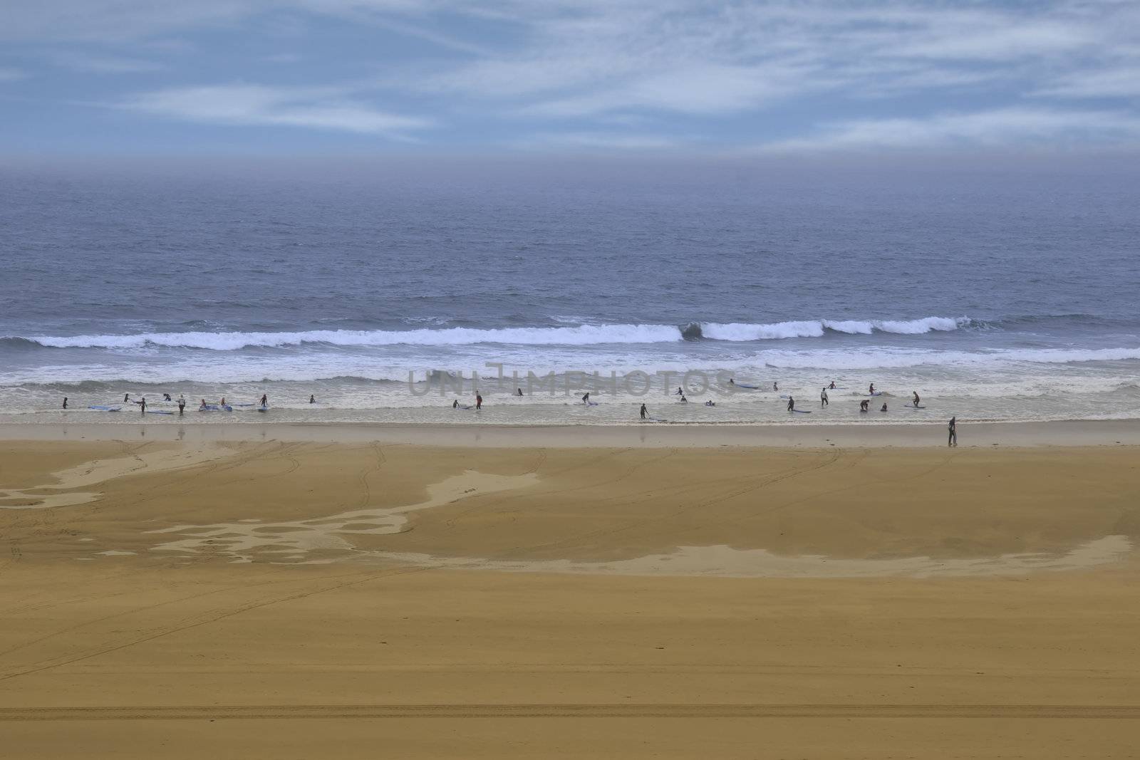 golden beach with children getting ready to be taught surfing in ballybunion county Kerry Ireland