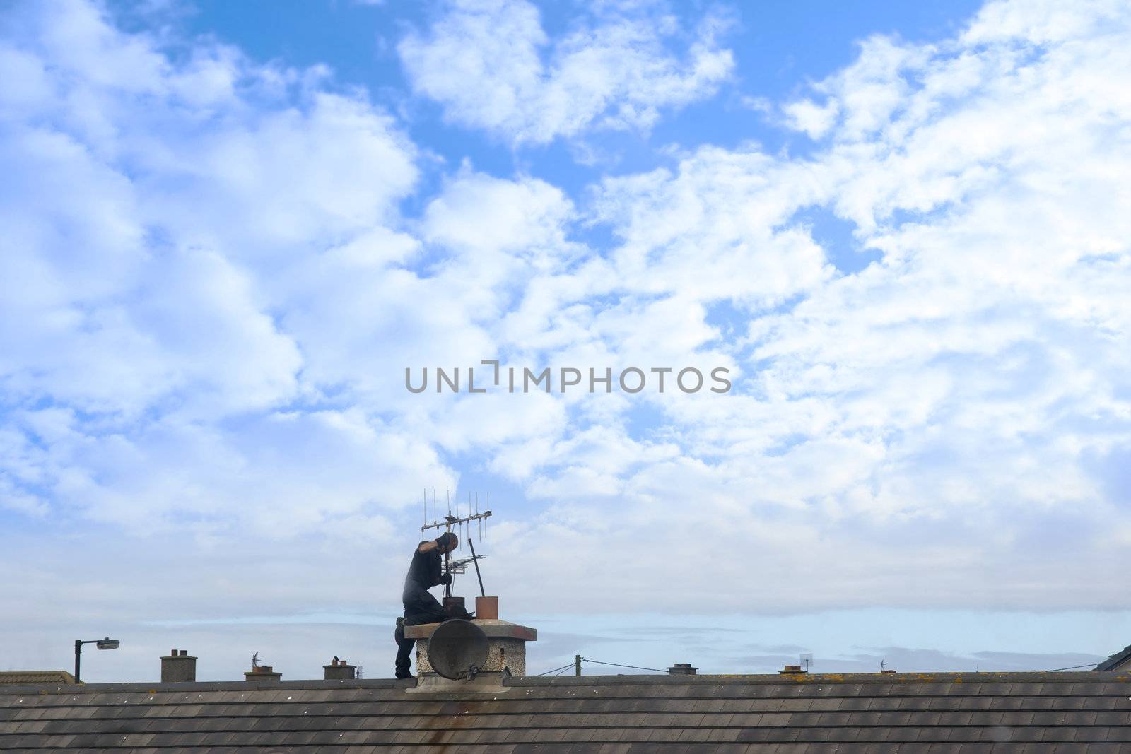 chimney sweep at work on the rooftop of a housing estate