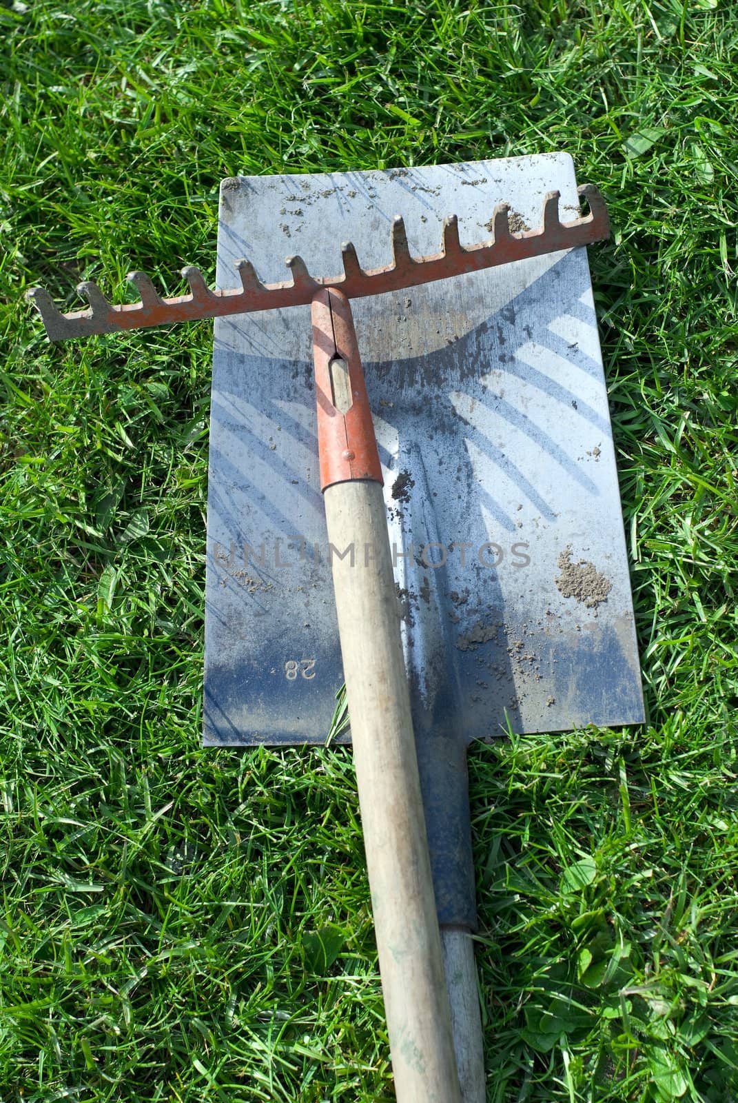 a shovel and a rake in the grass