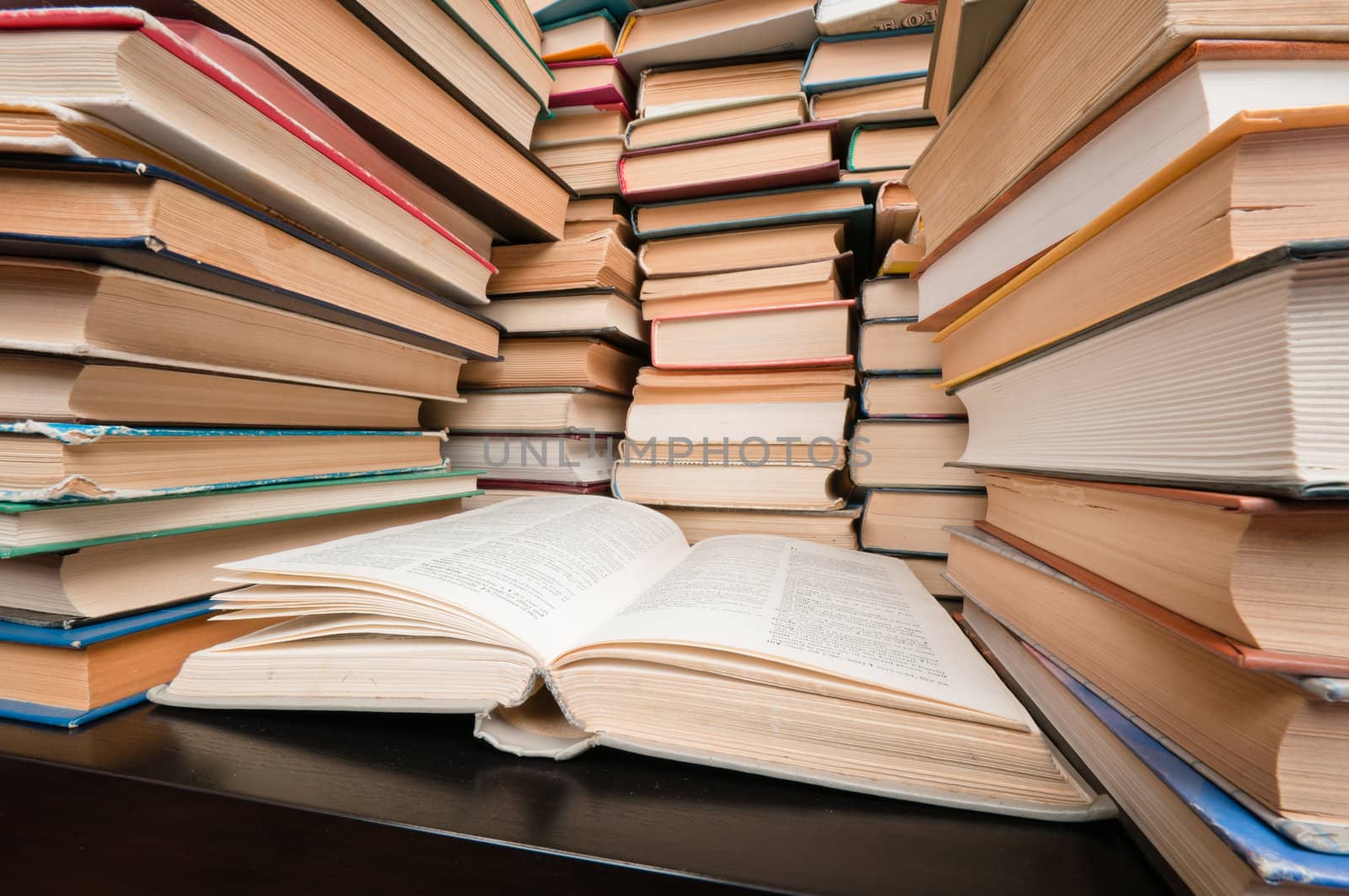 Big stacks of hardcovered books placed on black table