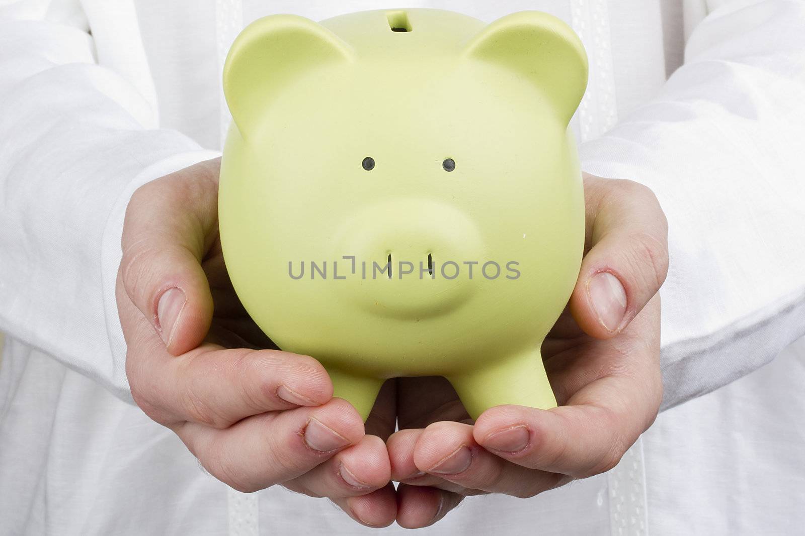 Close-up photograph of a green piggy bank in man's hands.