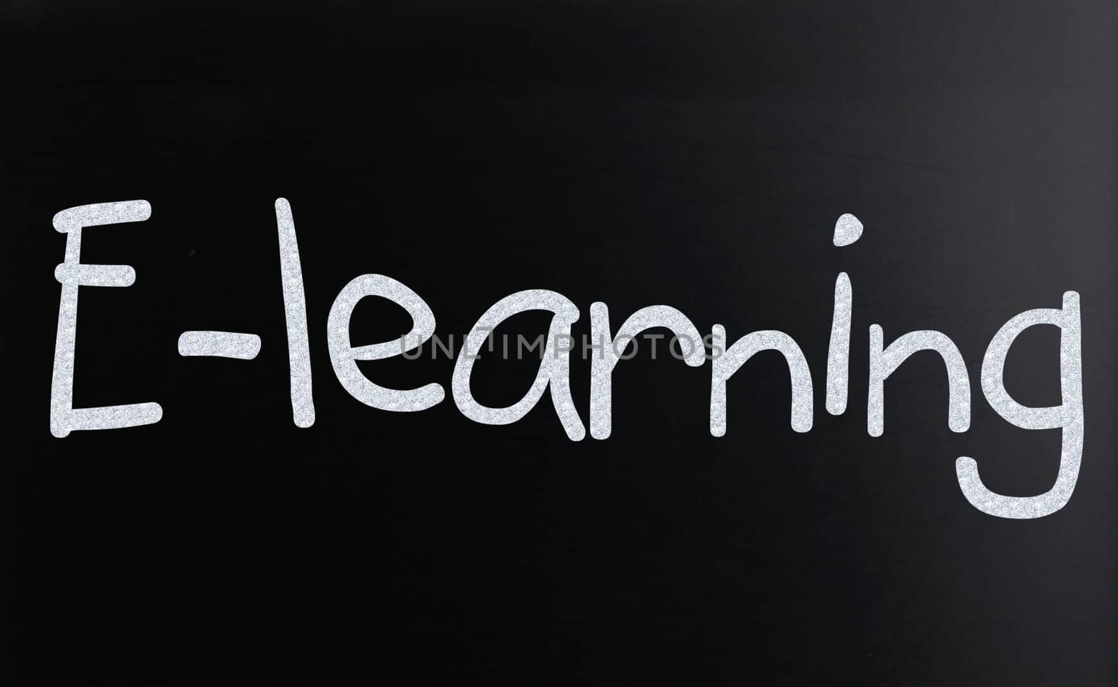 The word "E-learning" handwritten with white chalk on a blackboard