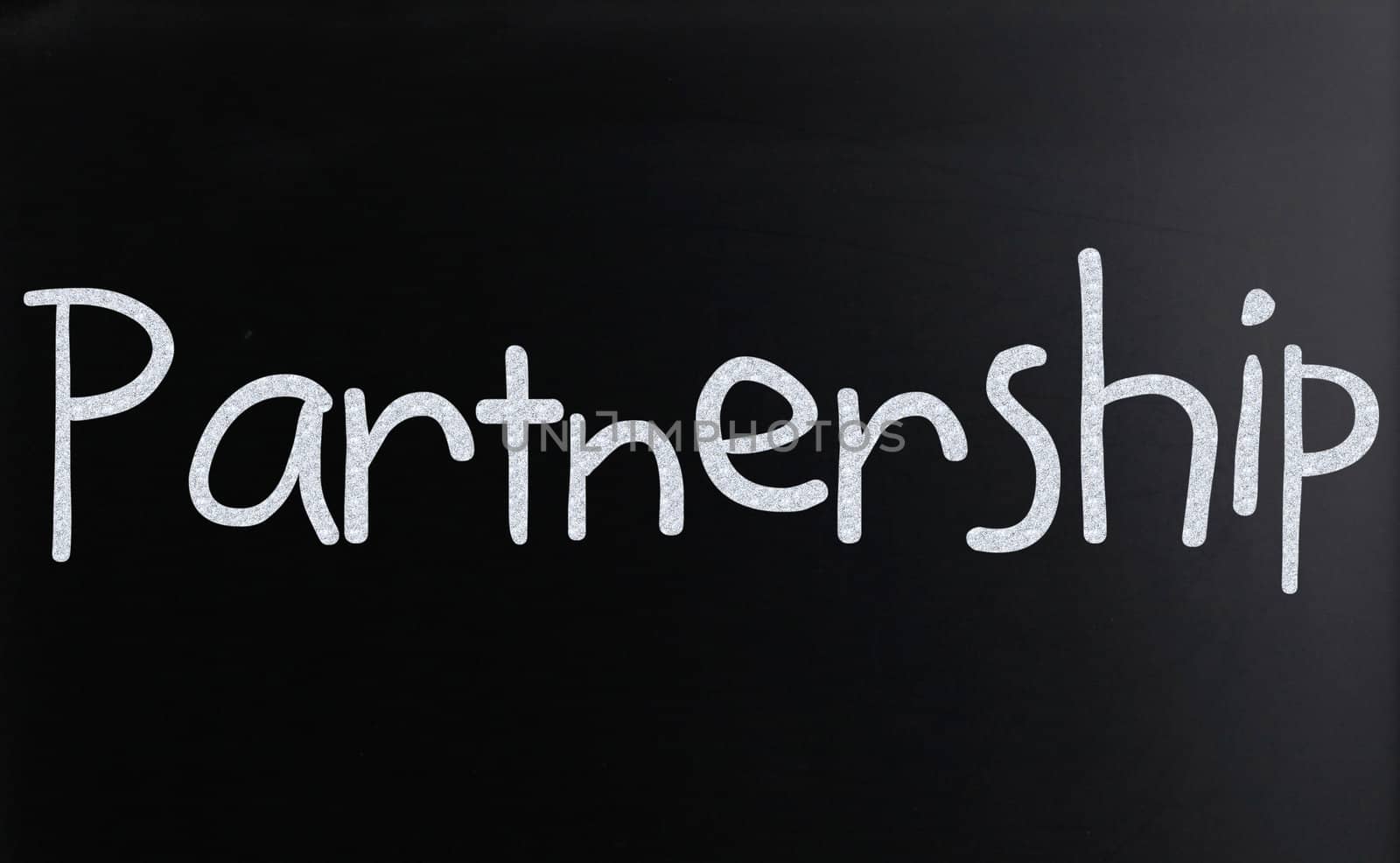 The word "Partnership" handwritten with white chalk on a blackboard
