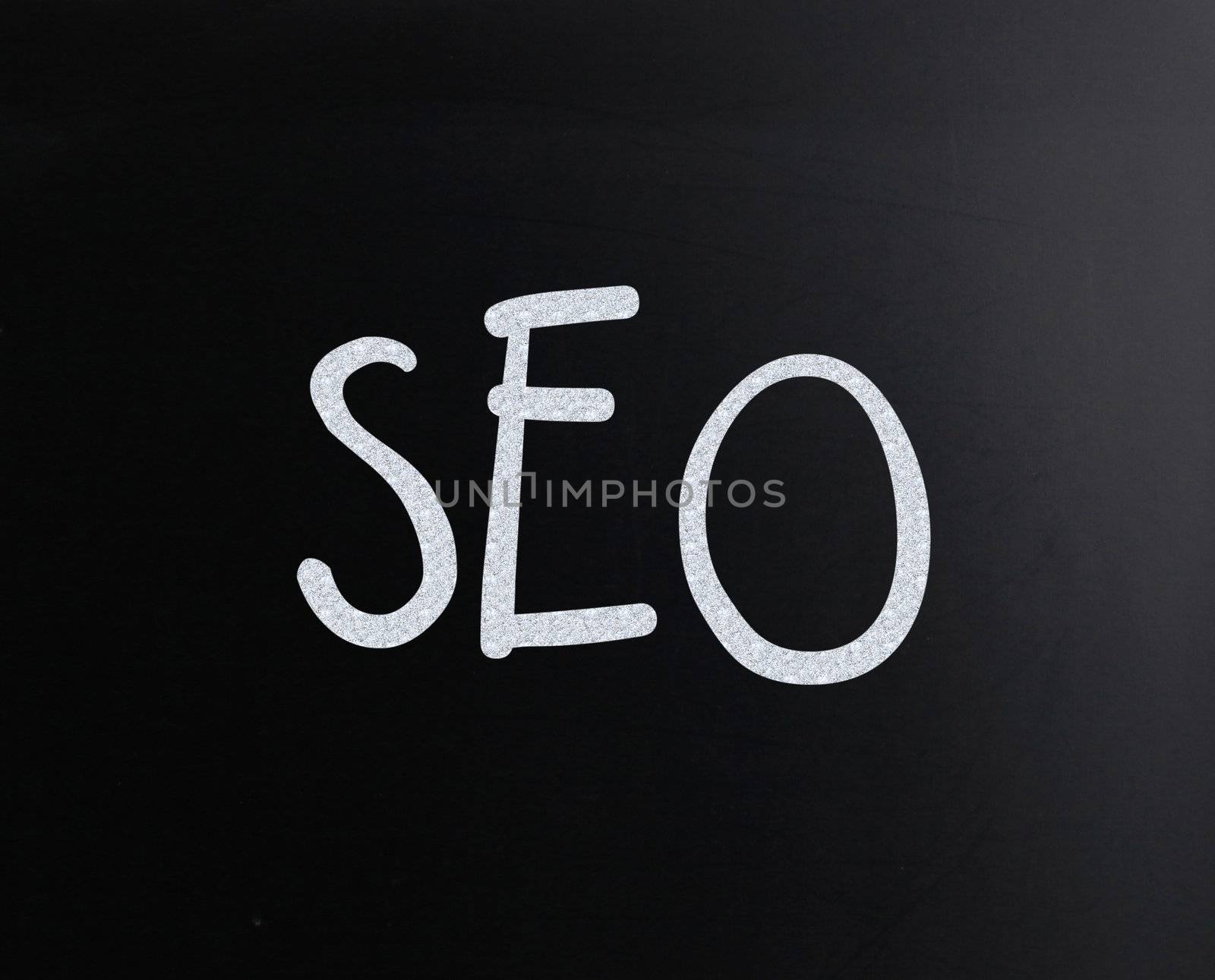 The word "SEO" handwritten with white chalk on a blackboard