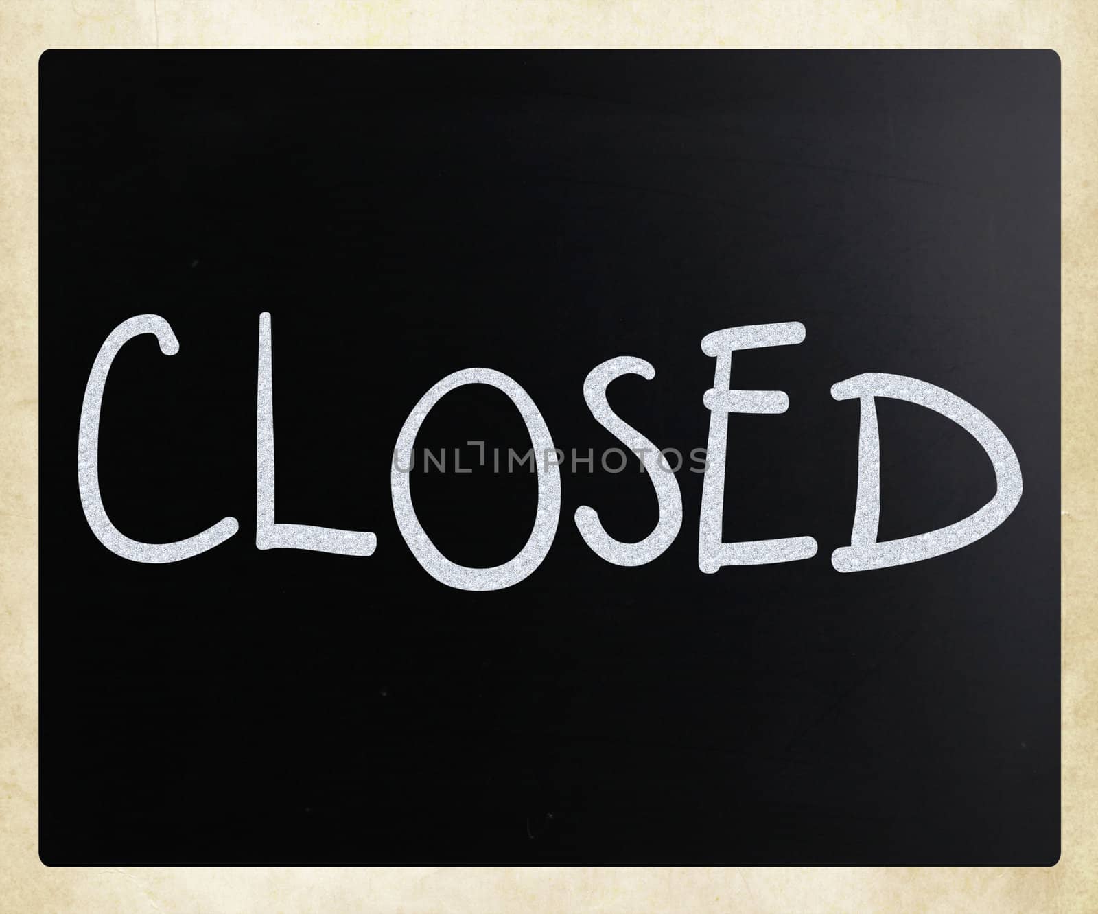 The word "Closed" handwritten with white chalk on a blackboard