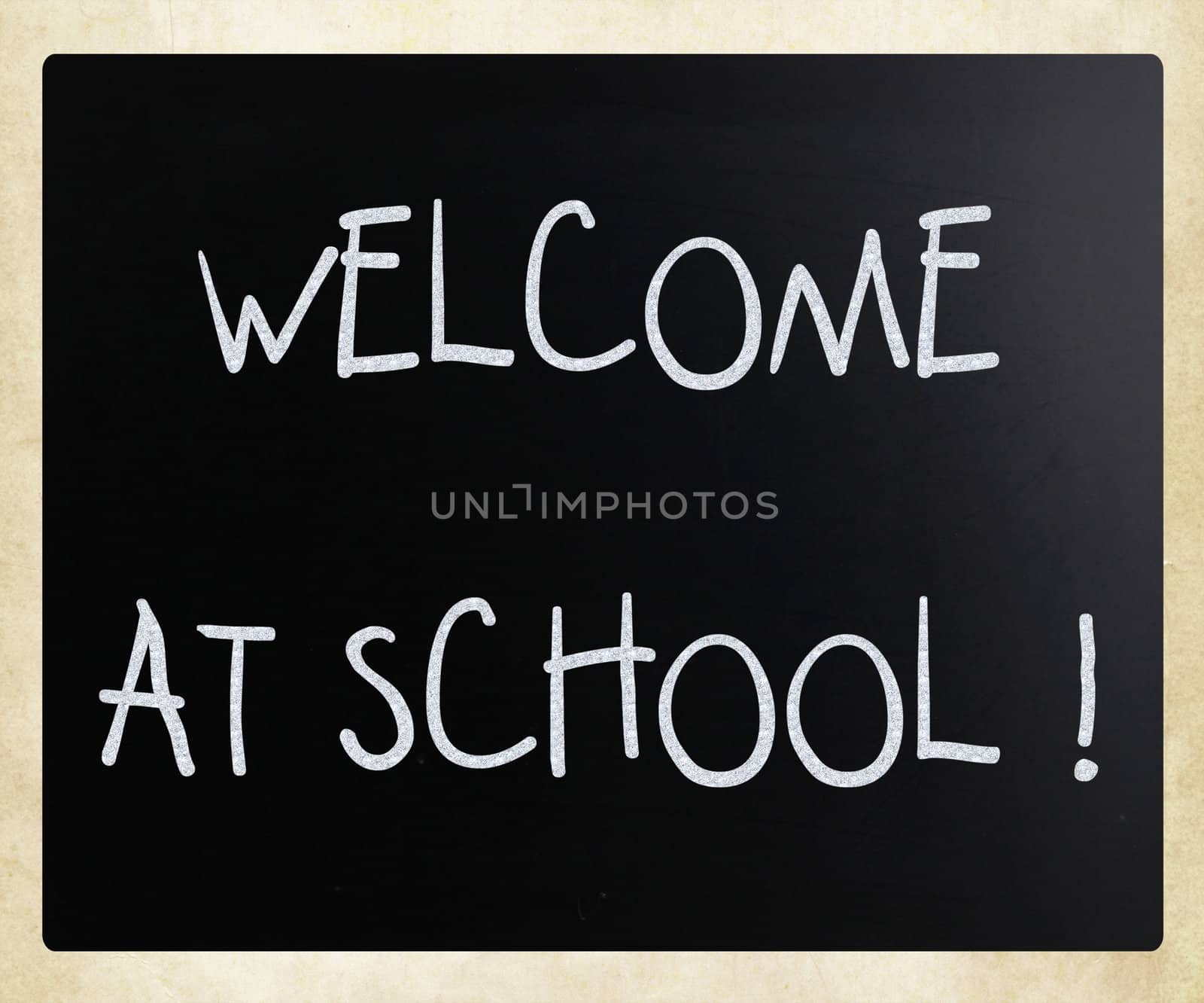 "Welcome at school" handwritten with white chalk on a blackboard