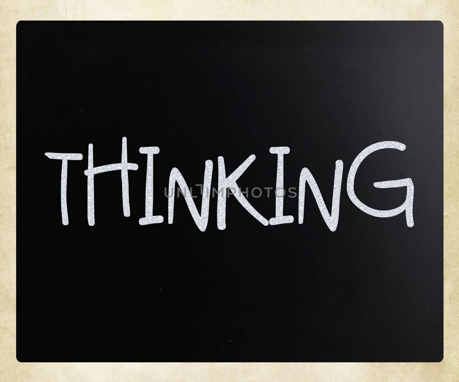 "Thinking" handwritten with white chalk on a blackboard