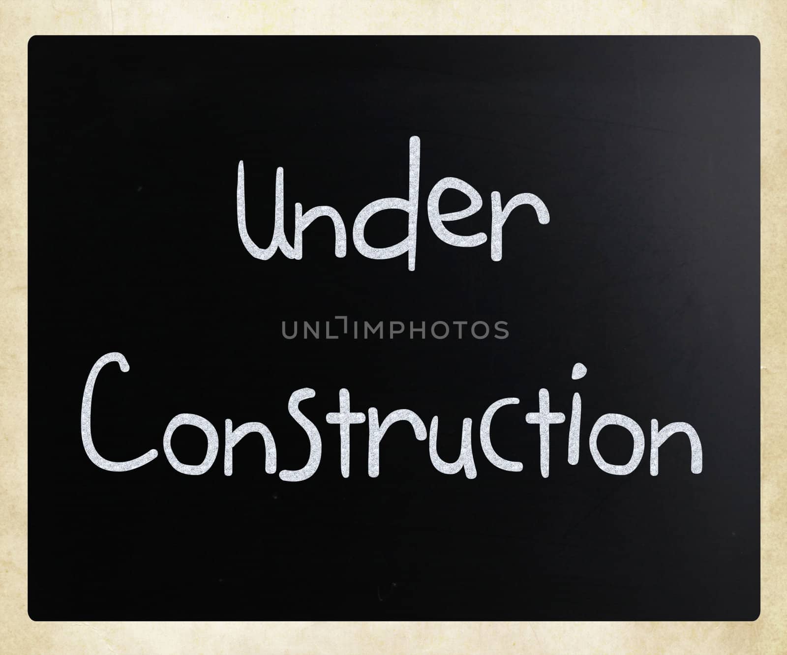 "Under construction" handwritten with white chalk on a blackboard