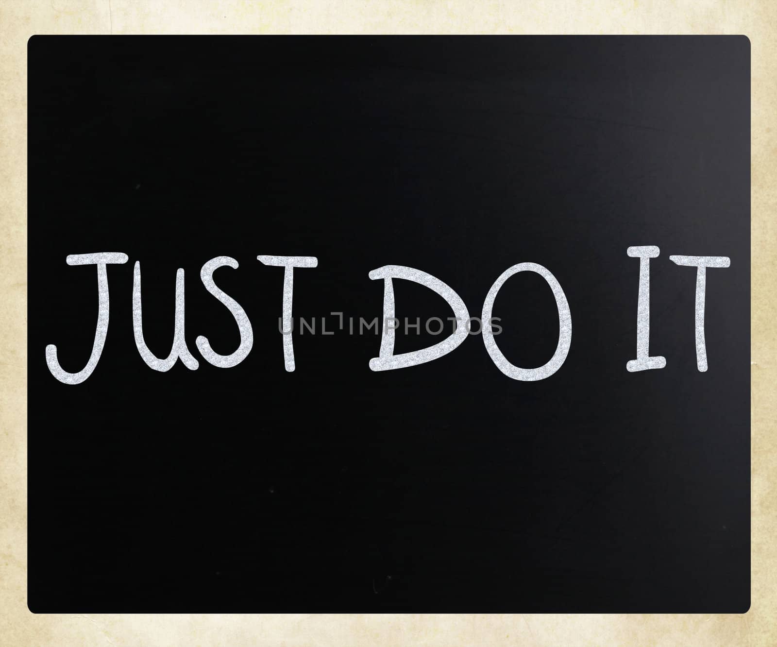 "Just Do It" handwritten with white chalk on a blackboard