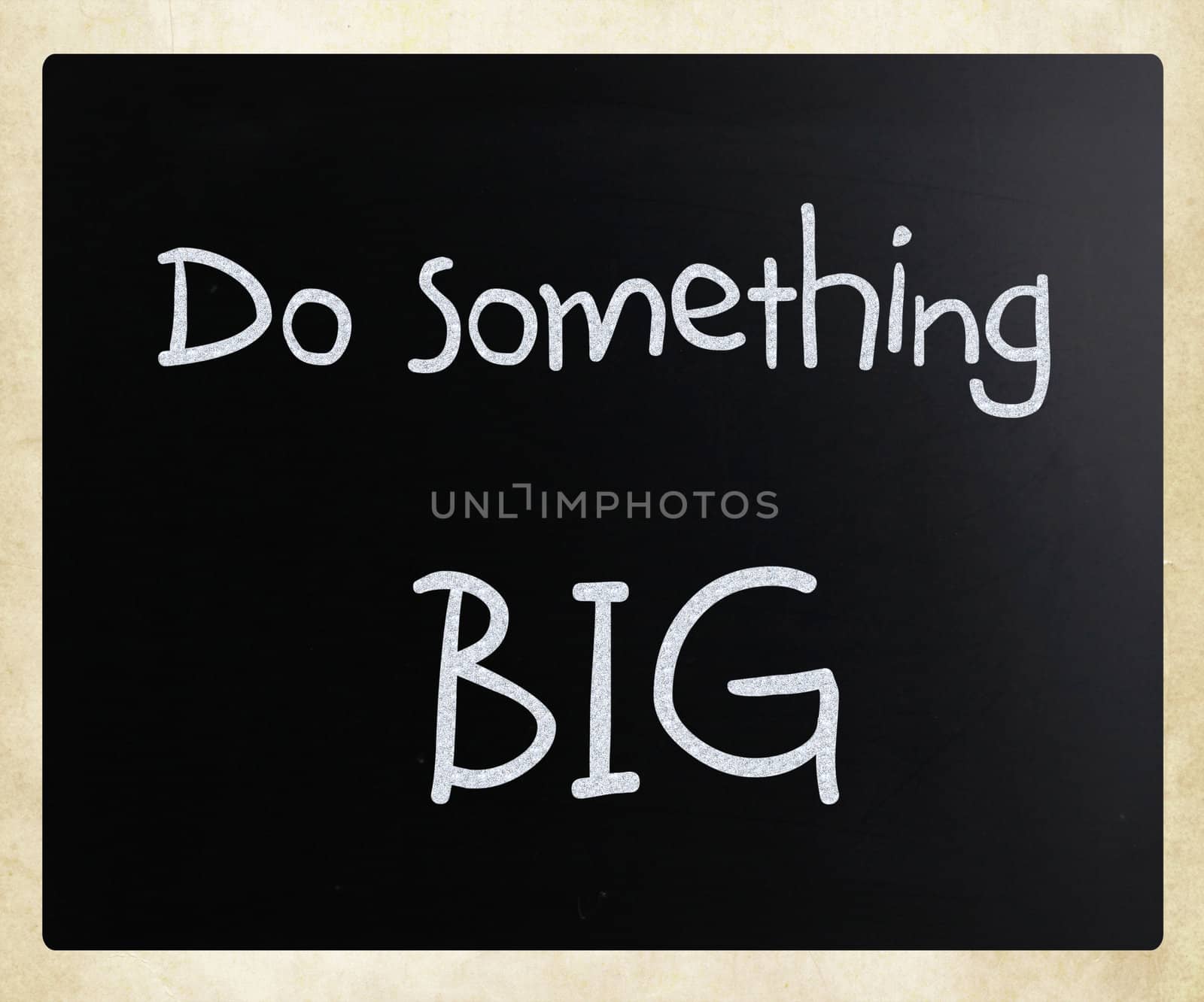 "Do something big" handwritten with white chalk on a blackboard