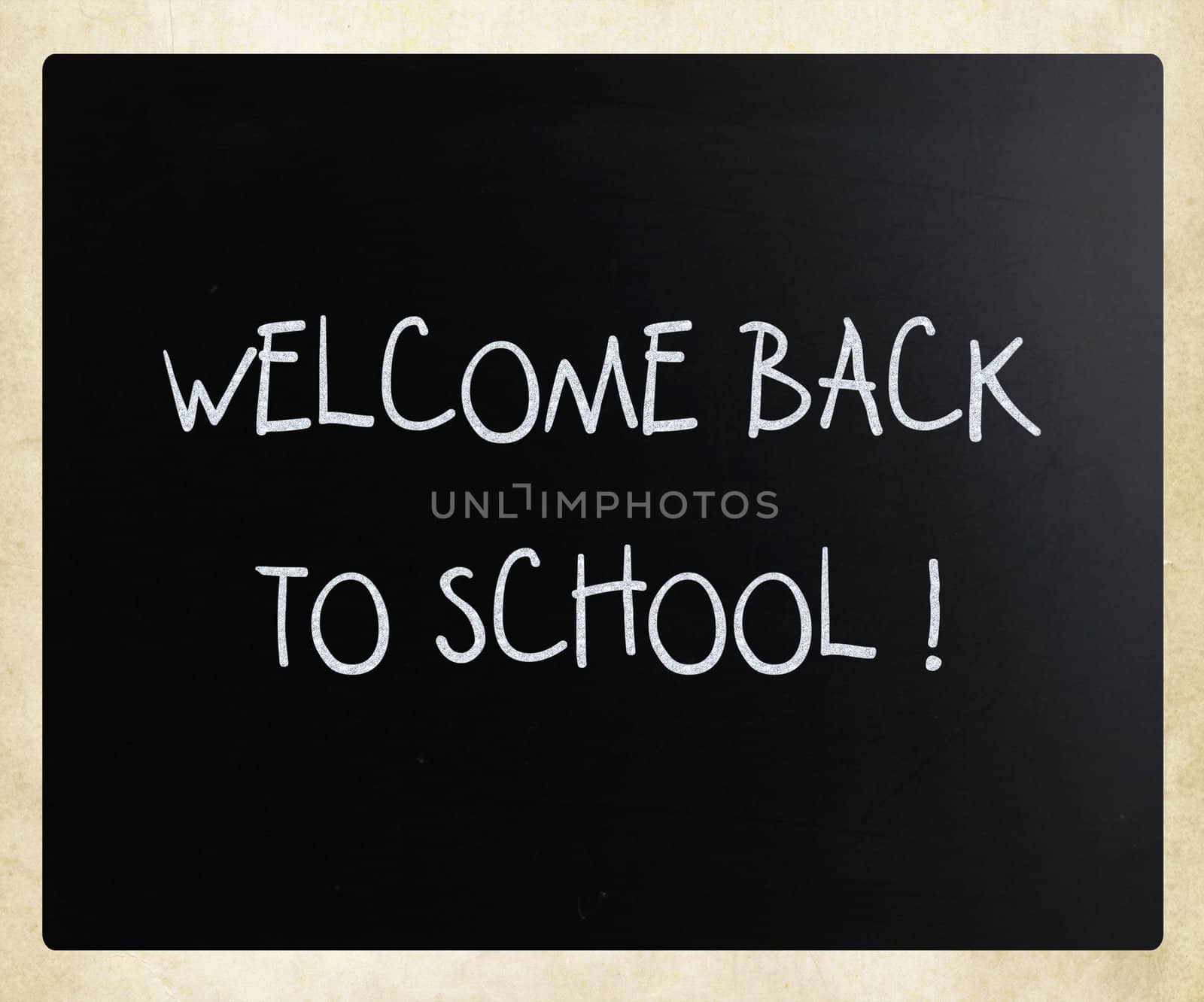 "Welcome back to school" handwritten with white chalk on a blackboard