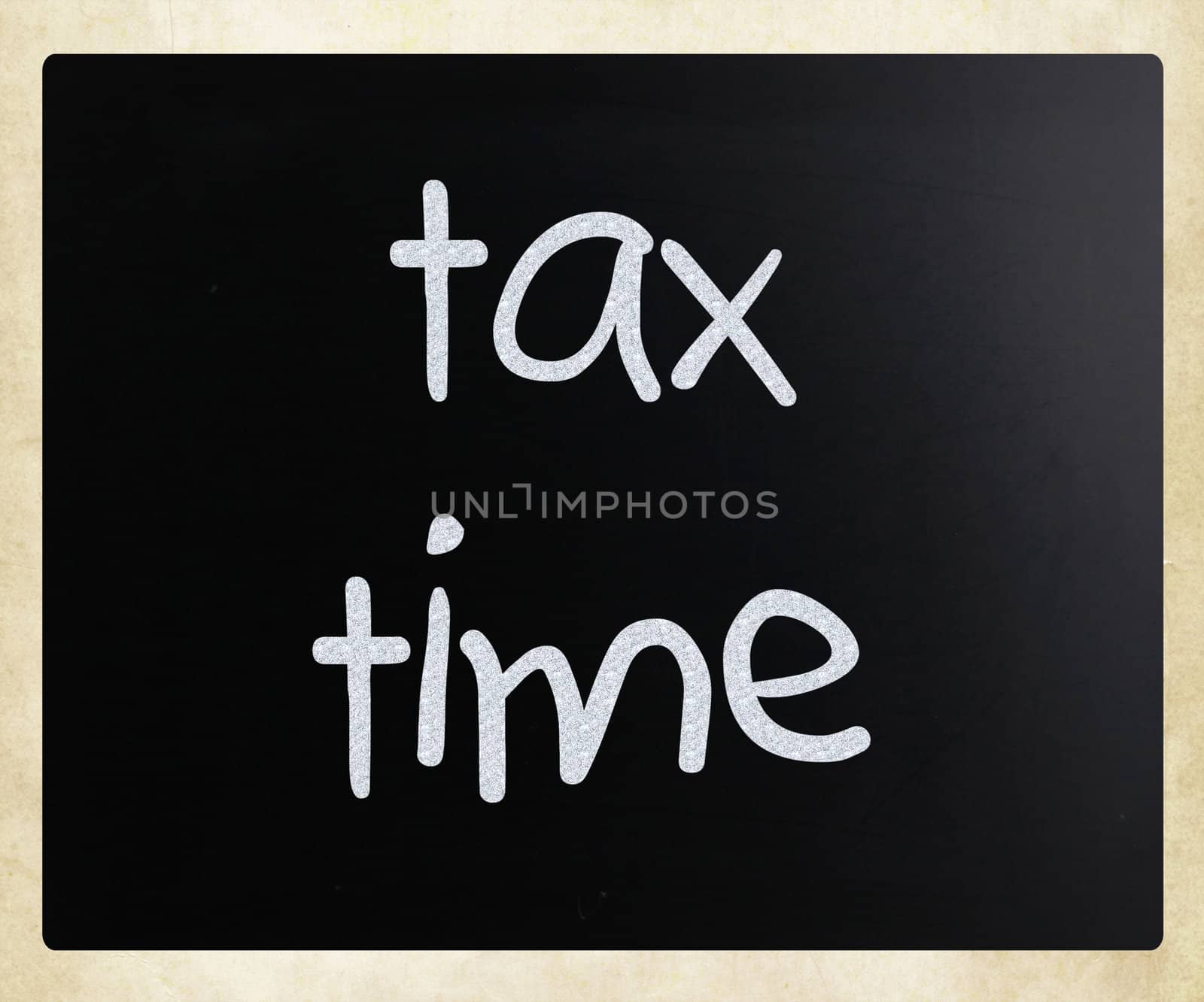 "Tax time" handwritten with white chalk on a blackboard