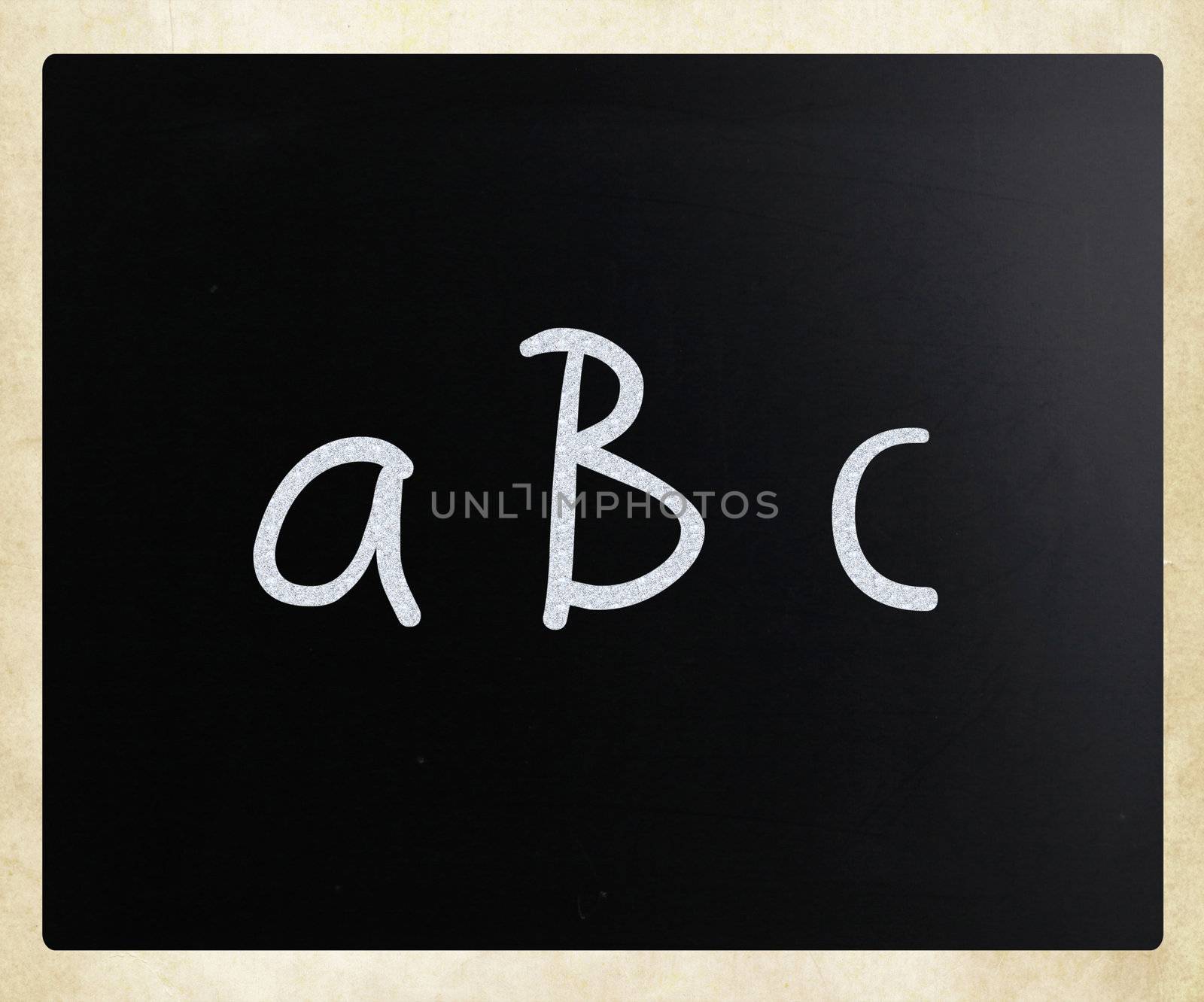 "abc" handwritten with white chalk on a blackboard