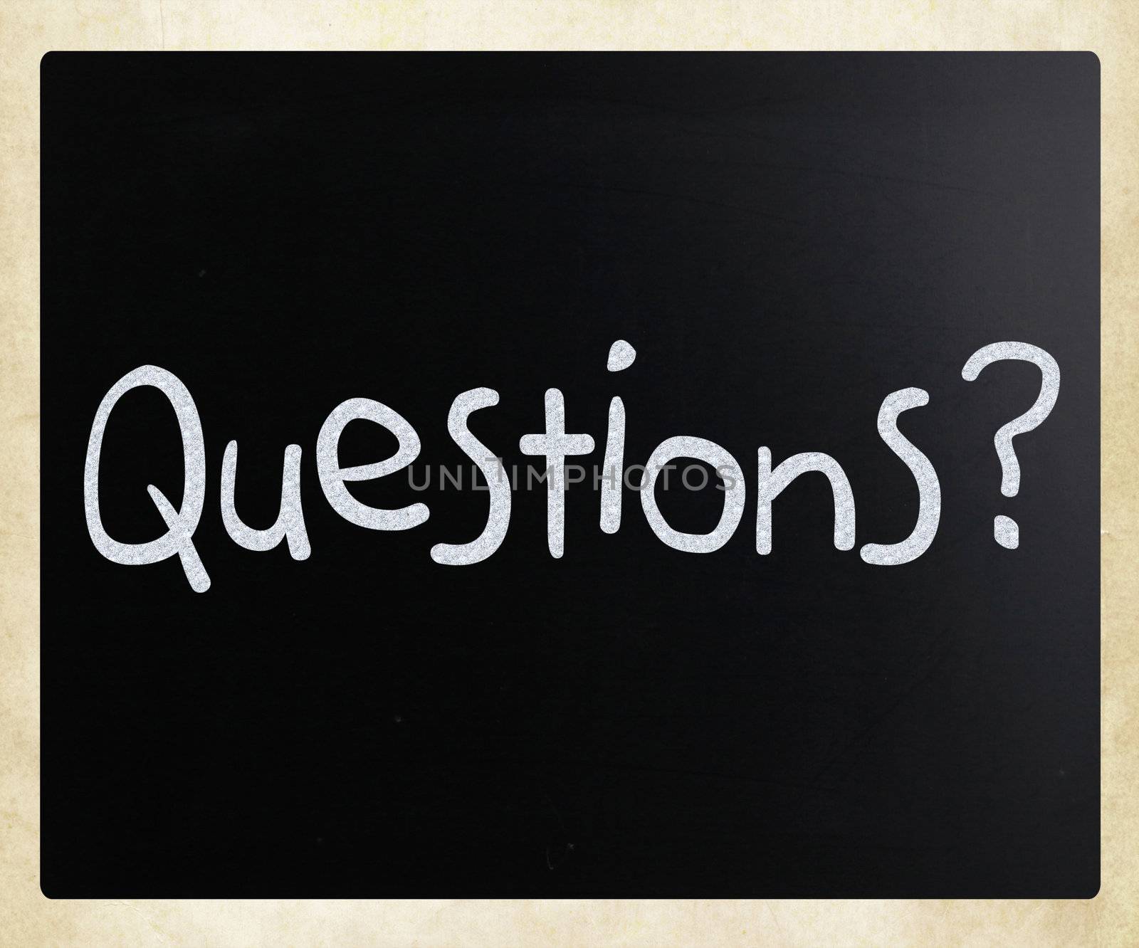 "Questions?" handwritten with white chalk on a blackboard