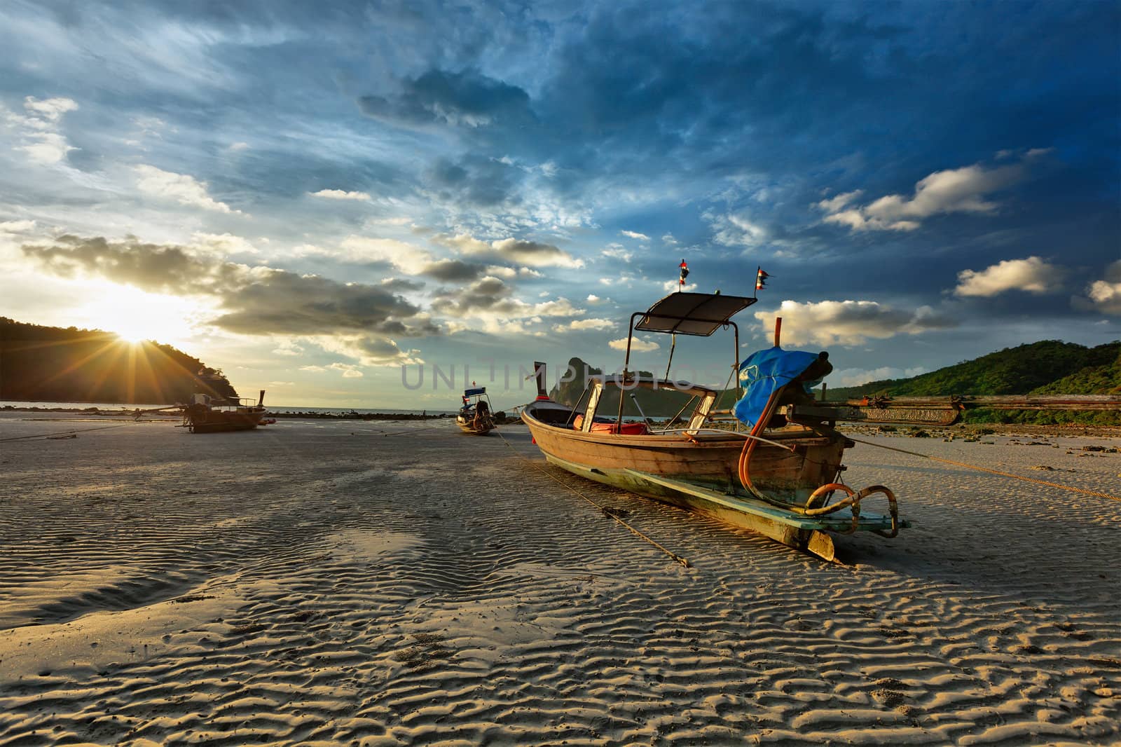 Long tail boat on beach on sunset on ebb. Thailand
