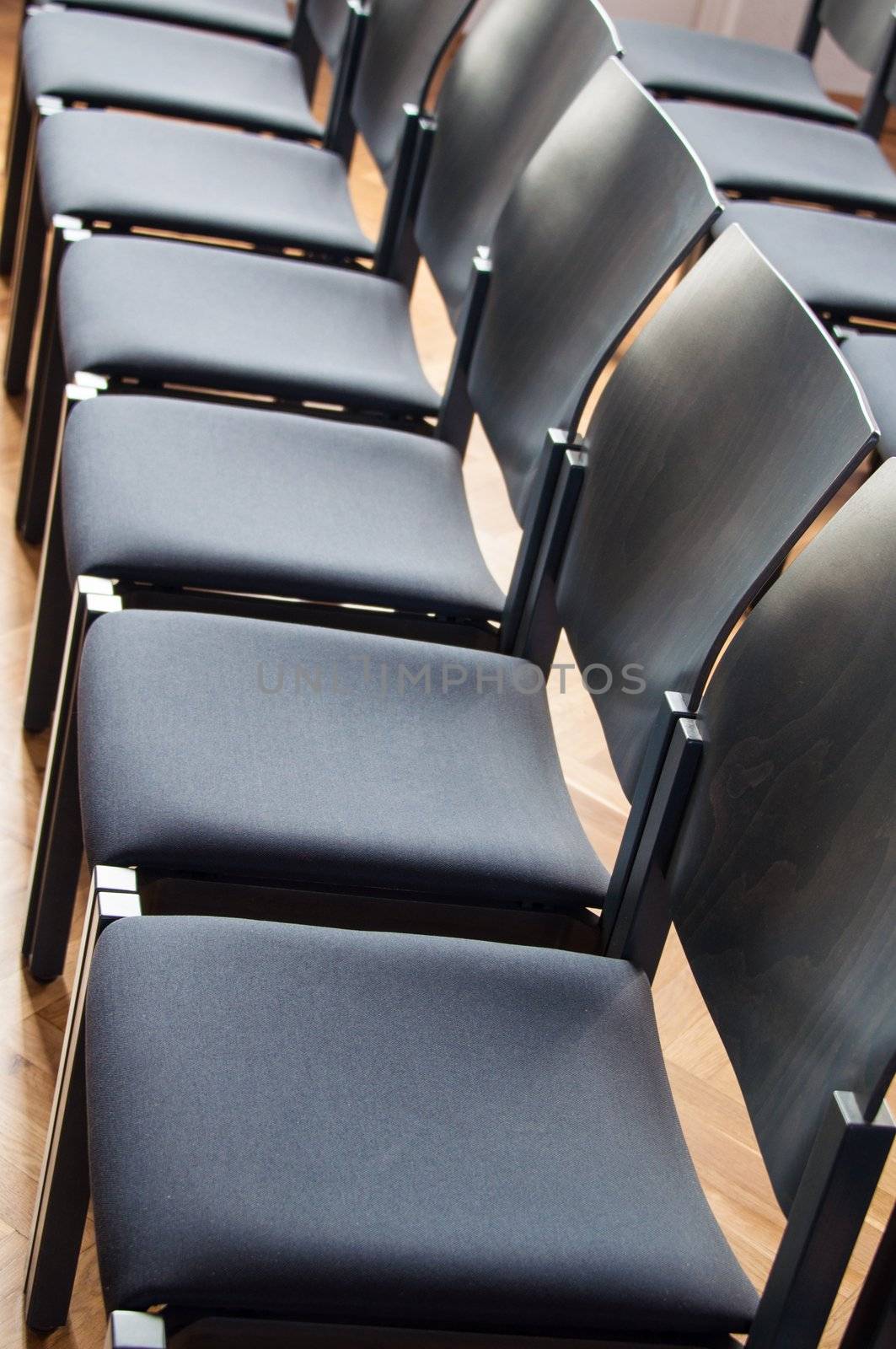 Rows of dark wooden and plastic chairs