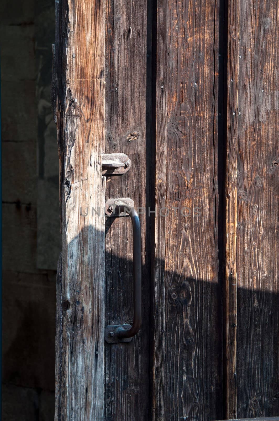 rustic wooden barn door with rusty metal handles