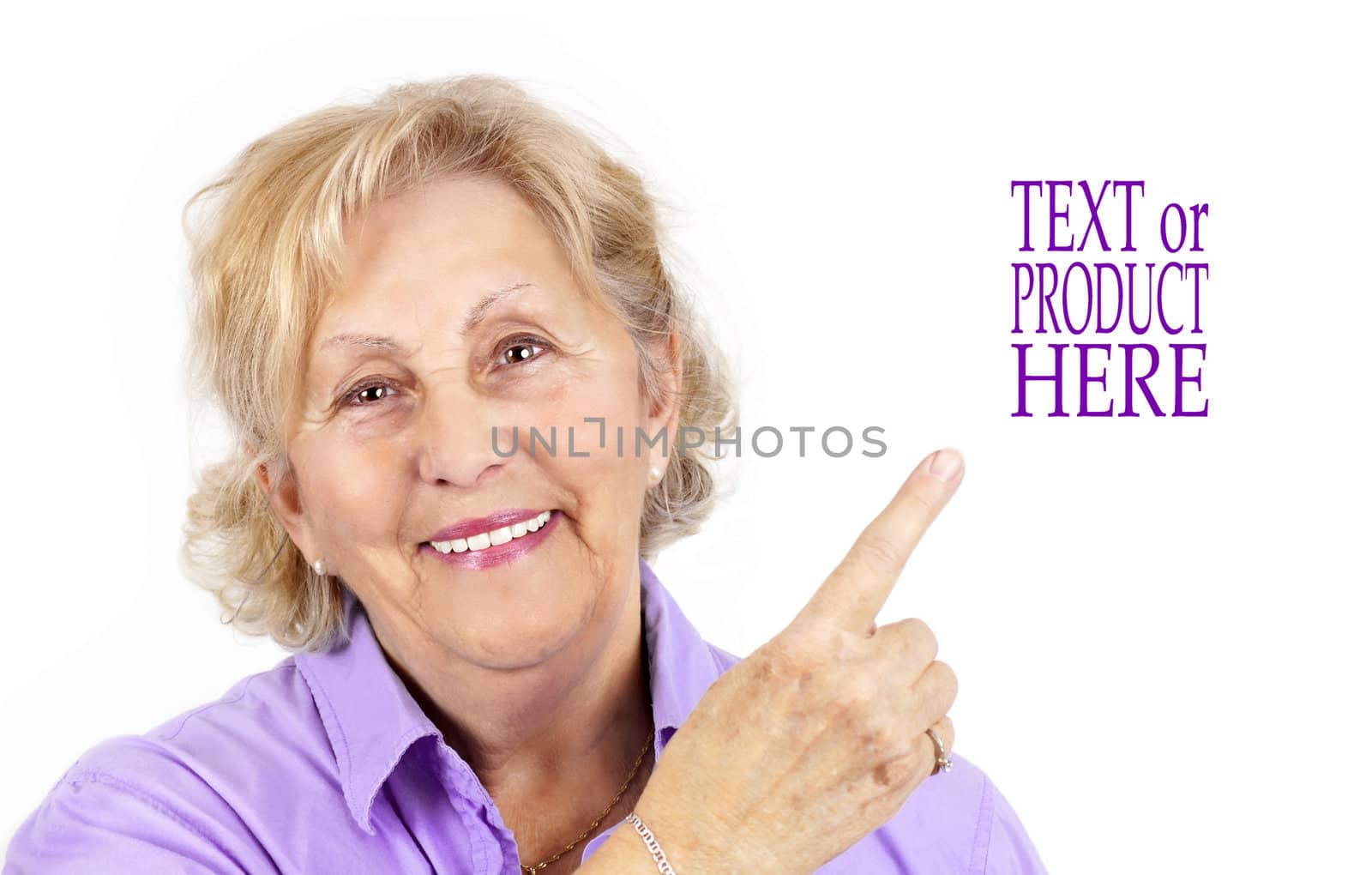 Beautiful senior woman smiling and pointing with her finger at blank space beside her, perfect ofr advertisement.