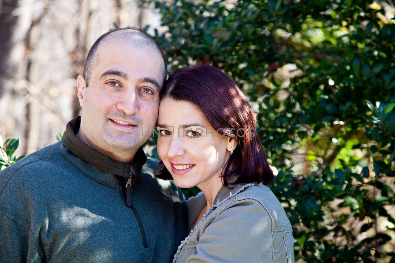 Portrait of smiling husband and wife couple hugging and looking at the camera.