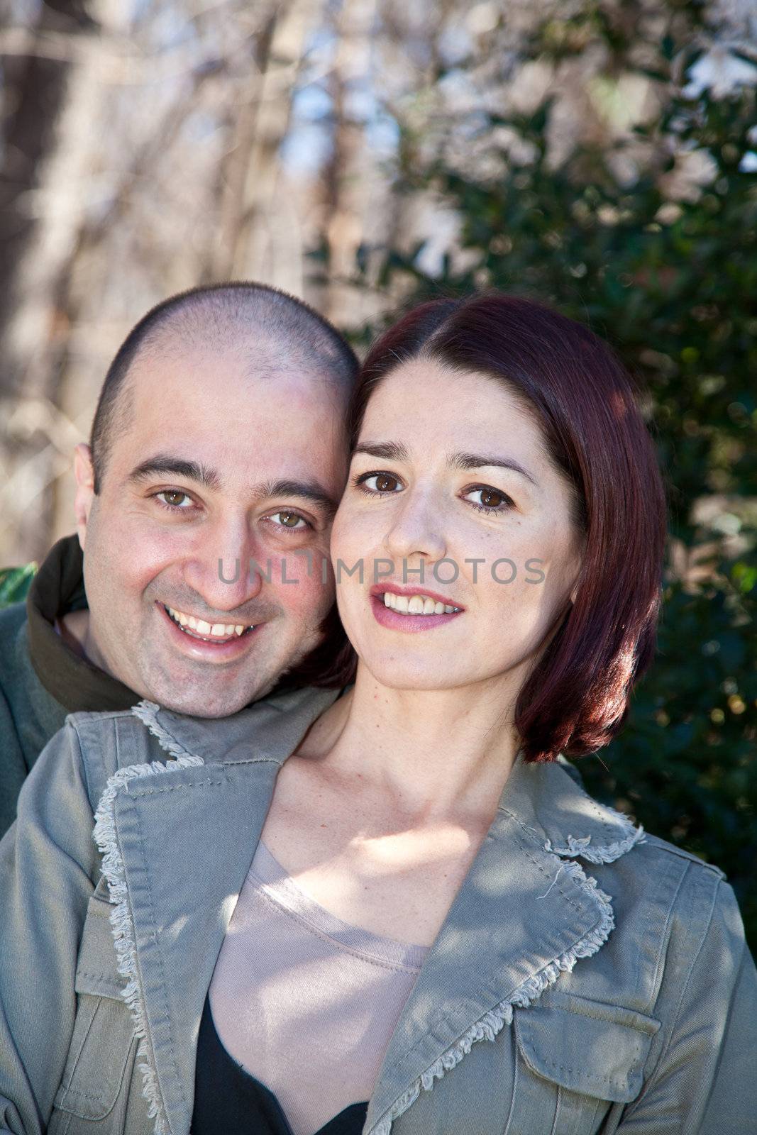 Portrait of smiling husband and wife couple hugging and looking at the camera.