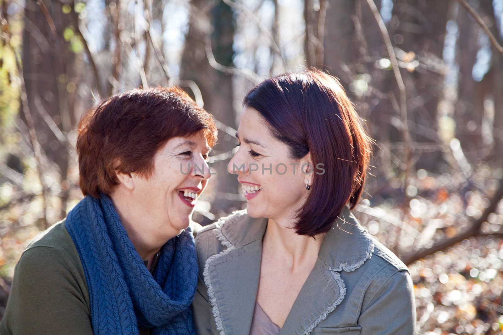 Portrait of women (mother and daughter) laughing at each other with love and affection.